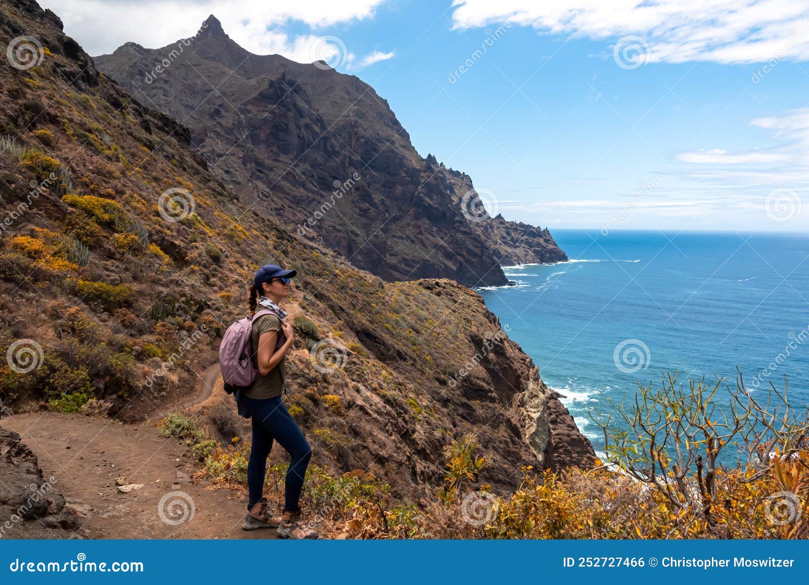 hiking woman with scenic view of coastline of anaga mountain range on tenerife, canary islands, spain. view on cabezo el tablero