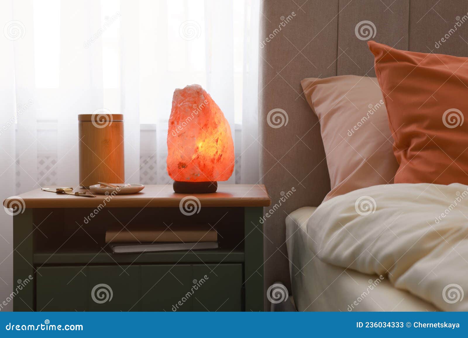 himalayan salt lamp, air ionizer and accessories on nightstand in bedroom