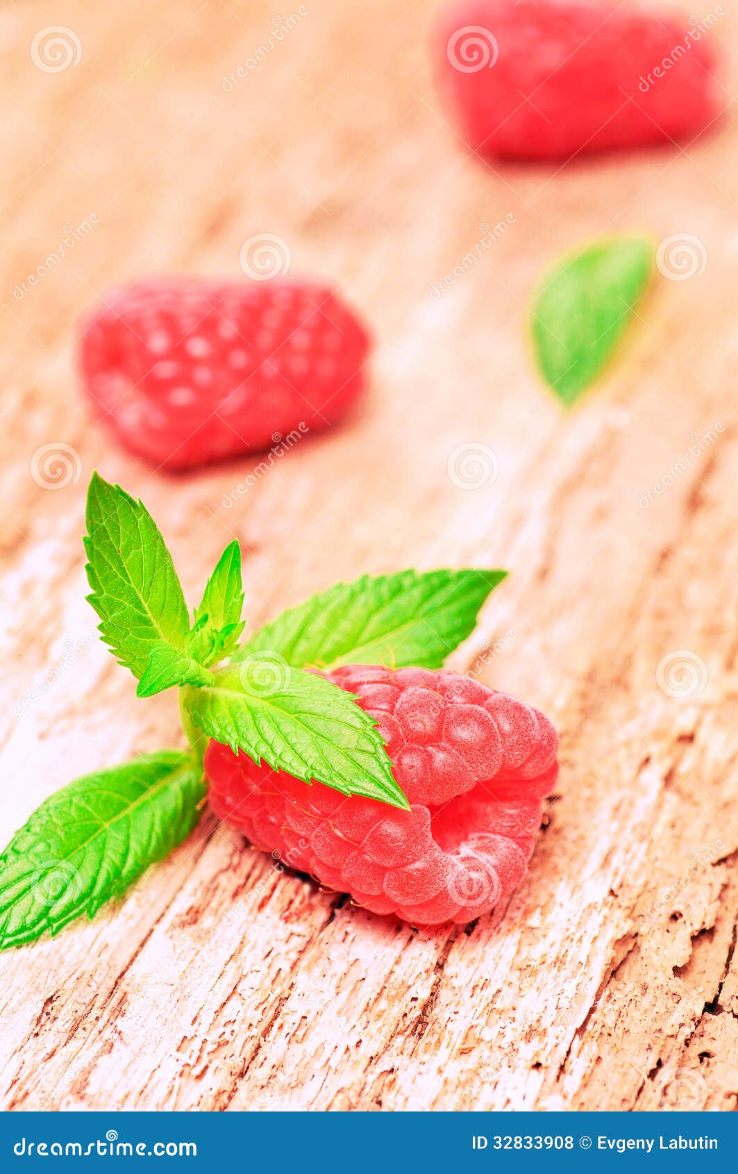 Frische saftige Himbeeren auf einem hölzernen Hintergrund