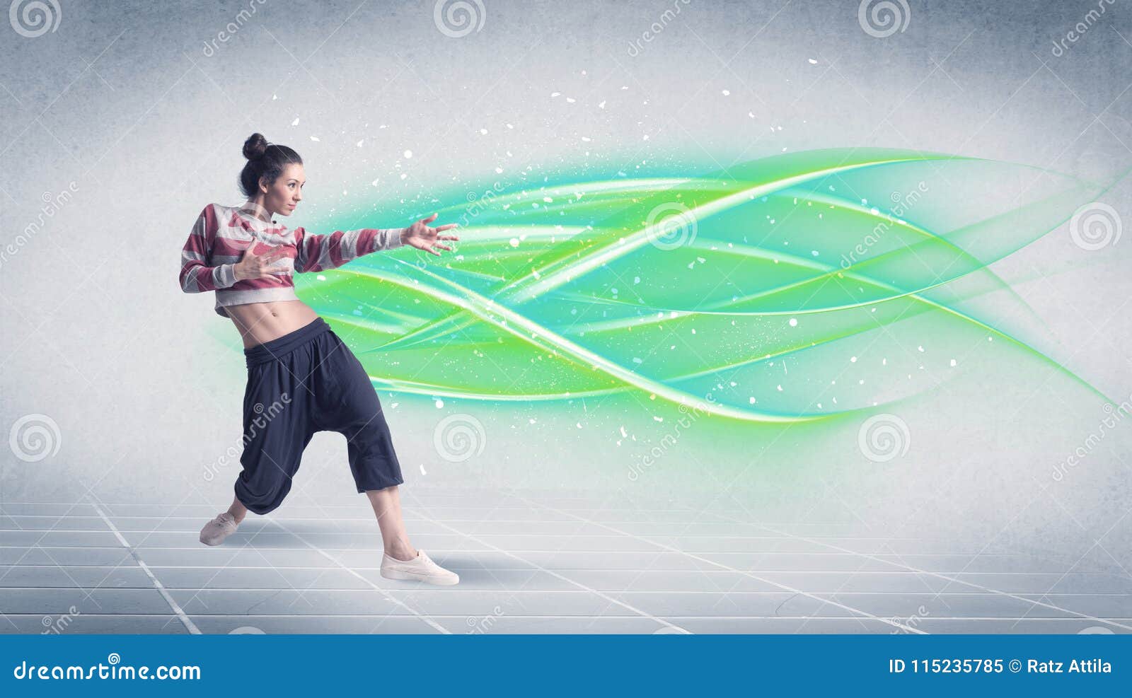 Hip hop tancerz pozuje z zielonymi linami. Dobry przyglądający świeży uliczny tancerza taniec przed popielatym tłem z białym, jaskrawym i kolorowym zielonej liny pojęciem,