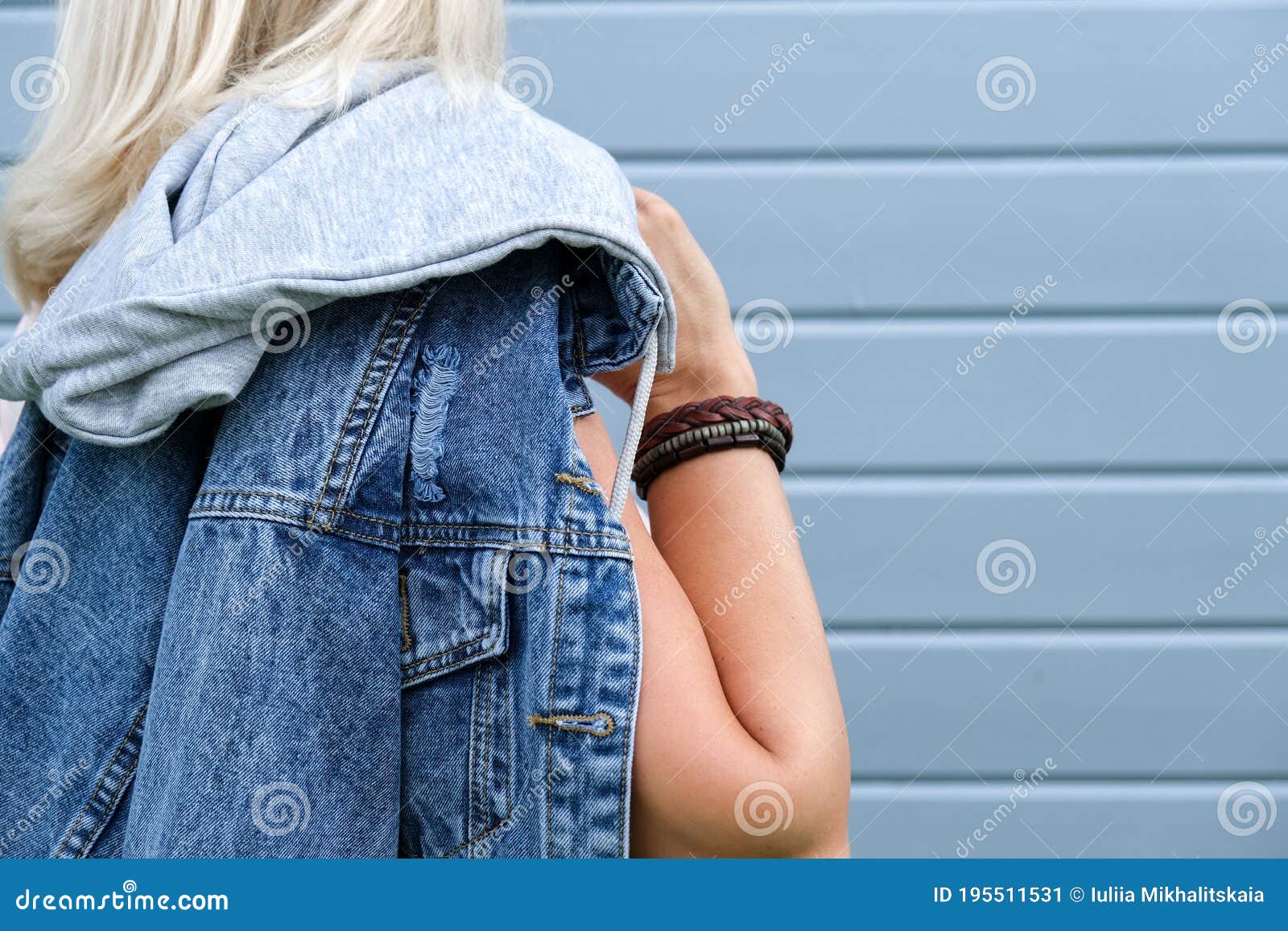 hippie woman wearing jeans, denim jacket and boho leather accessories on a hand wrist, bohemian style freepeople