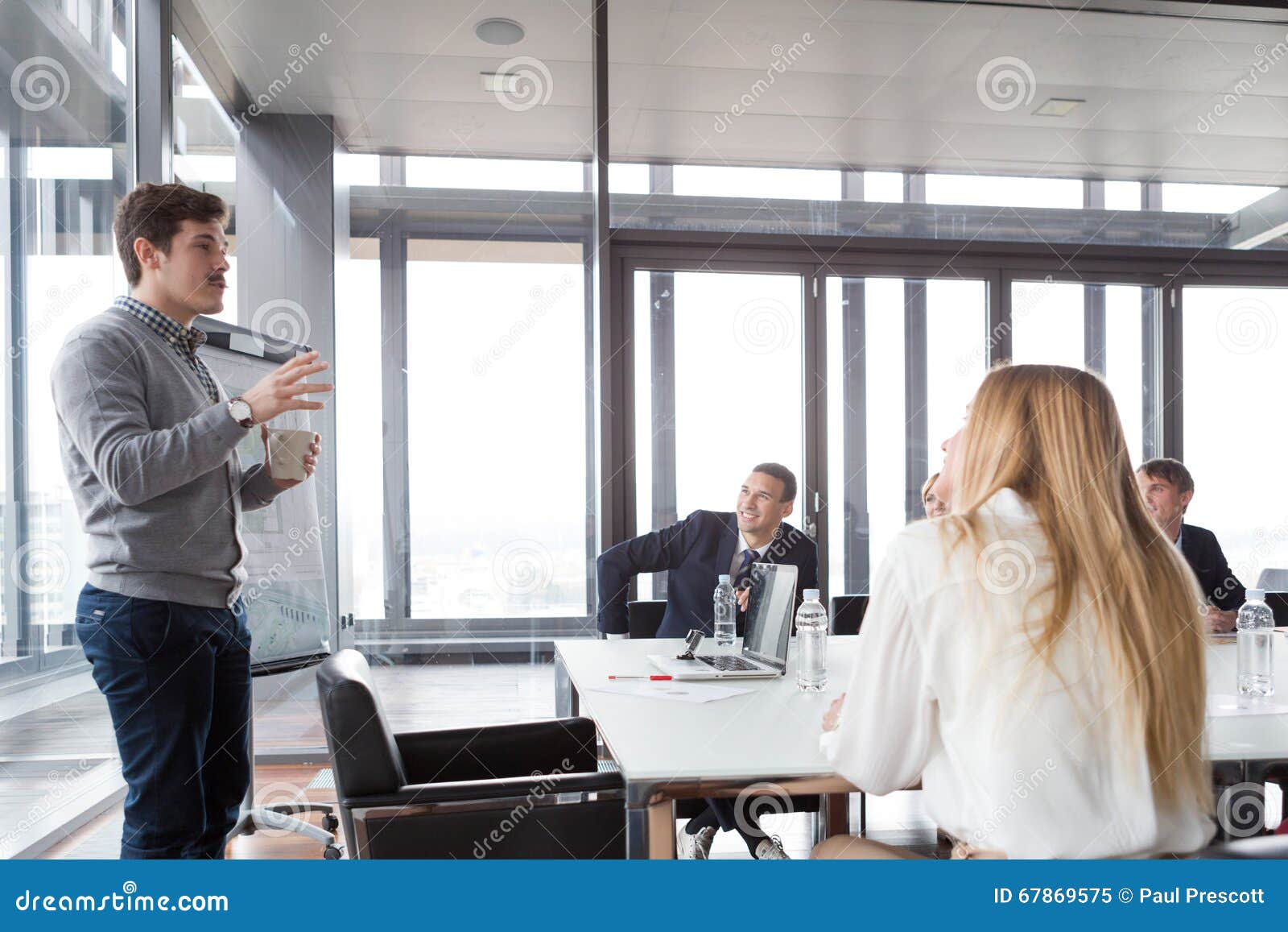 hipster business man holding coffee cup and presenting the project