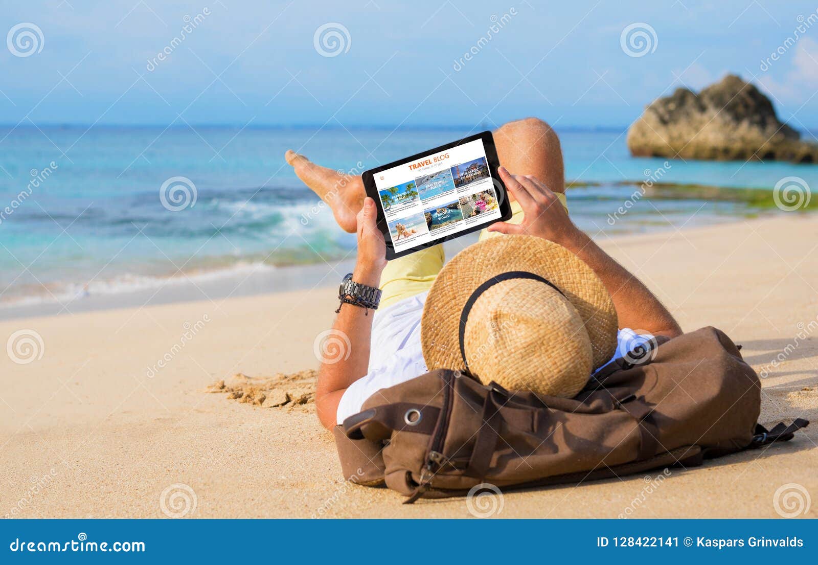 man reading travel blog on beach