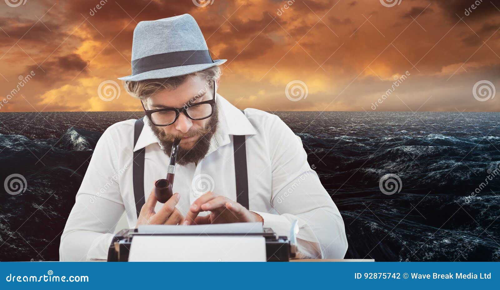 Hipster Smoking Pipe while Using Typewriter Against Sea Stock Photo