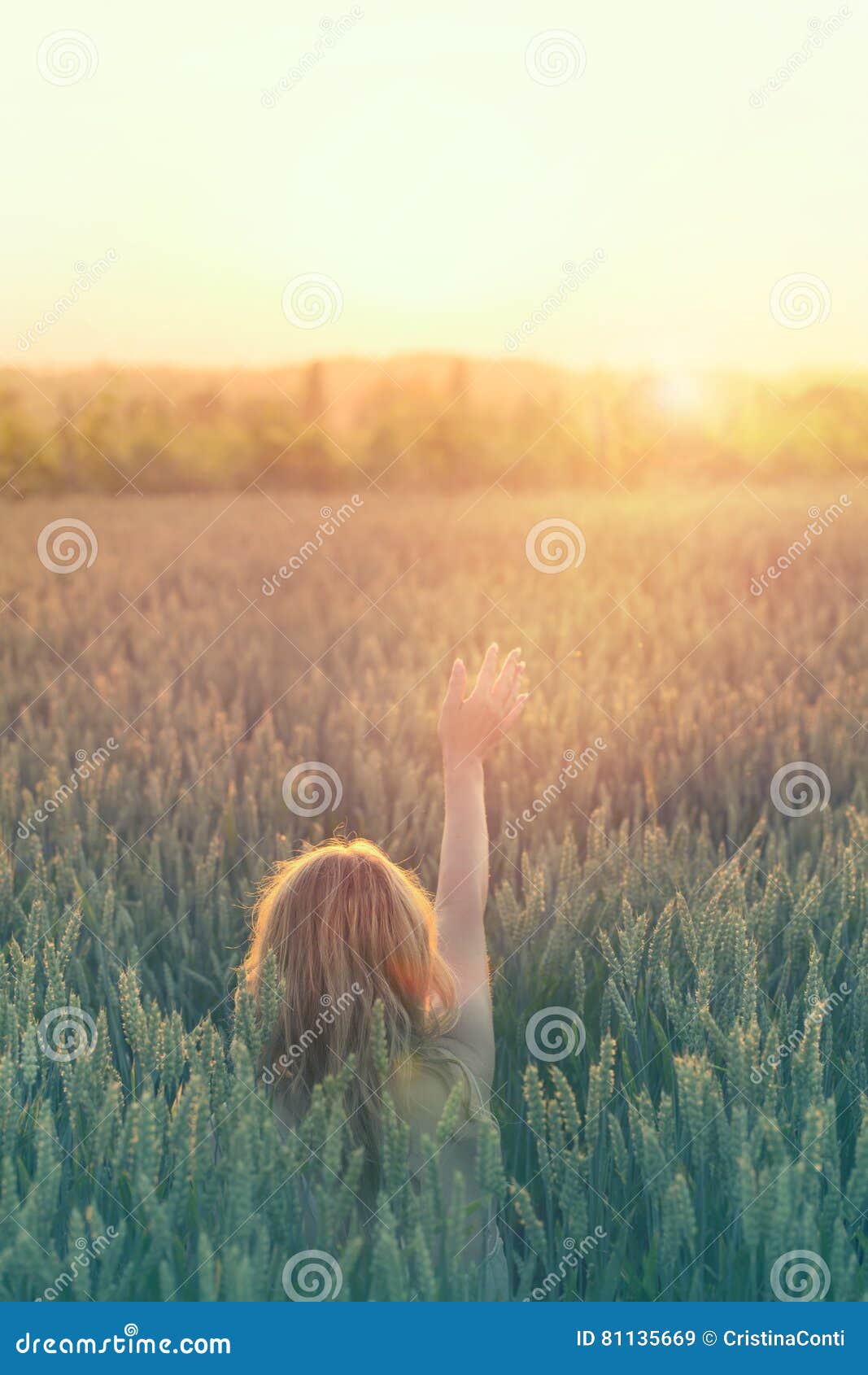hipster woman touches the sun with her hand in the middle of the nature