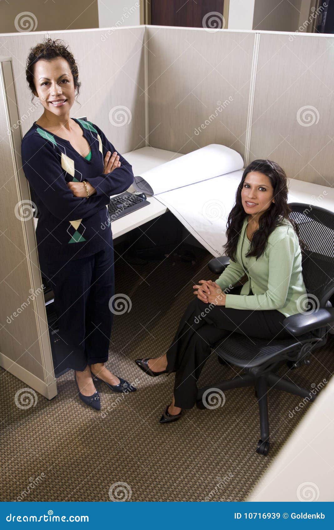 hispanic businesswomen in cubicle