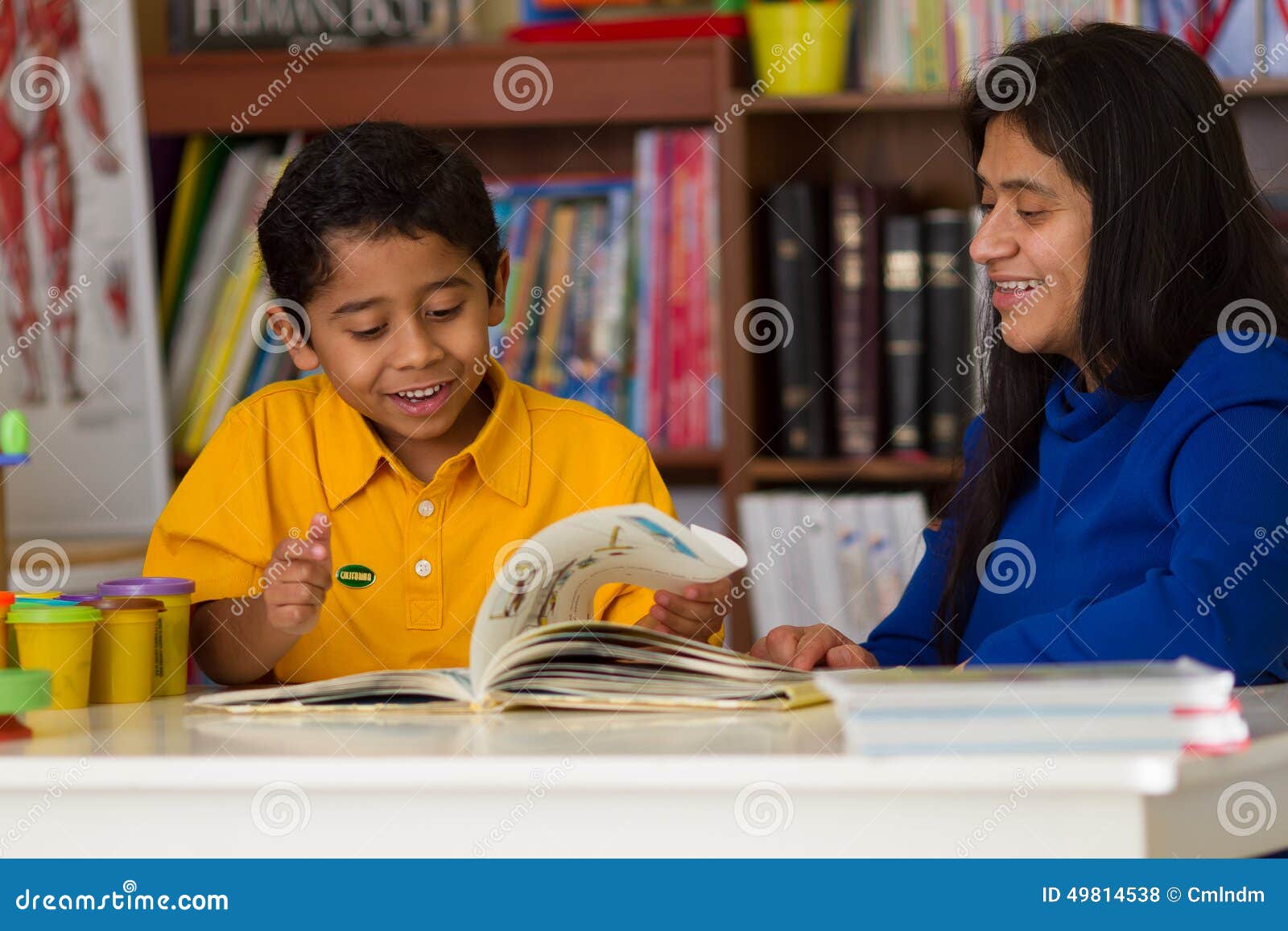 hispanic child learning to read with mom