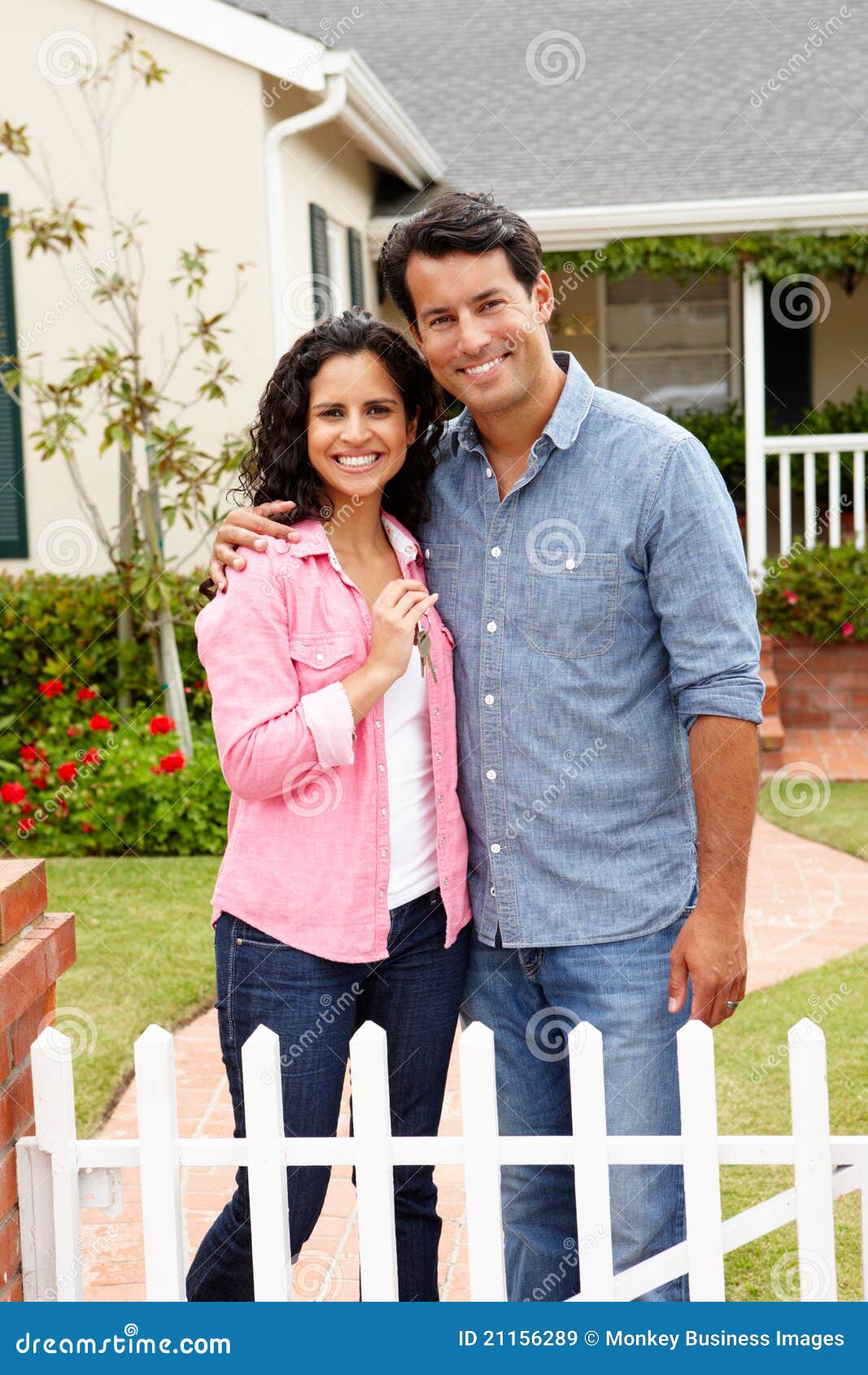 hispanic couple outside new home