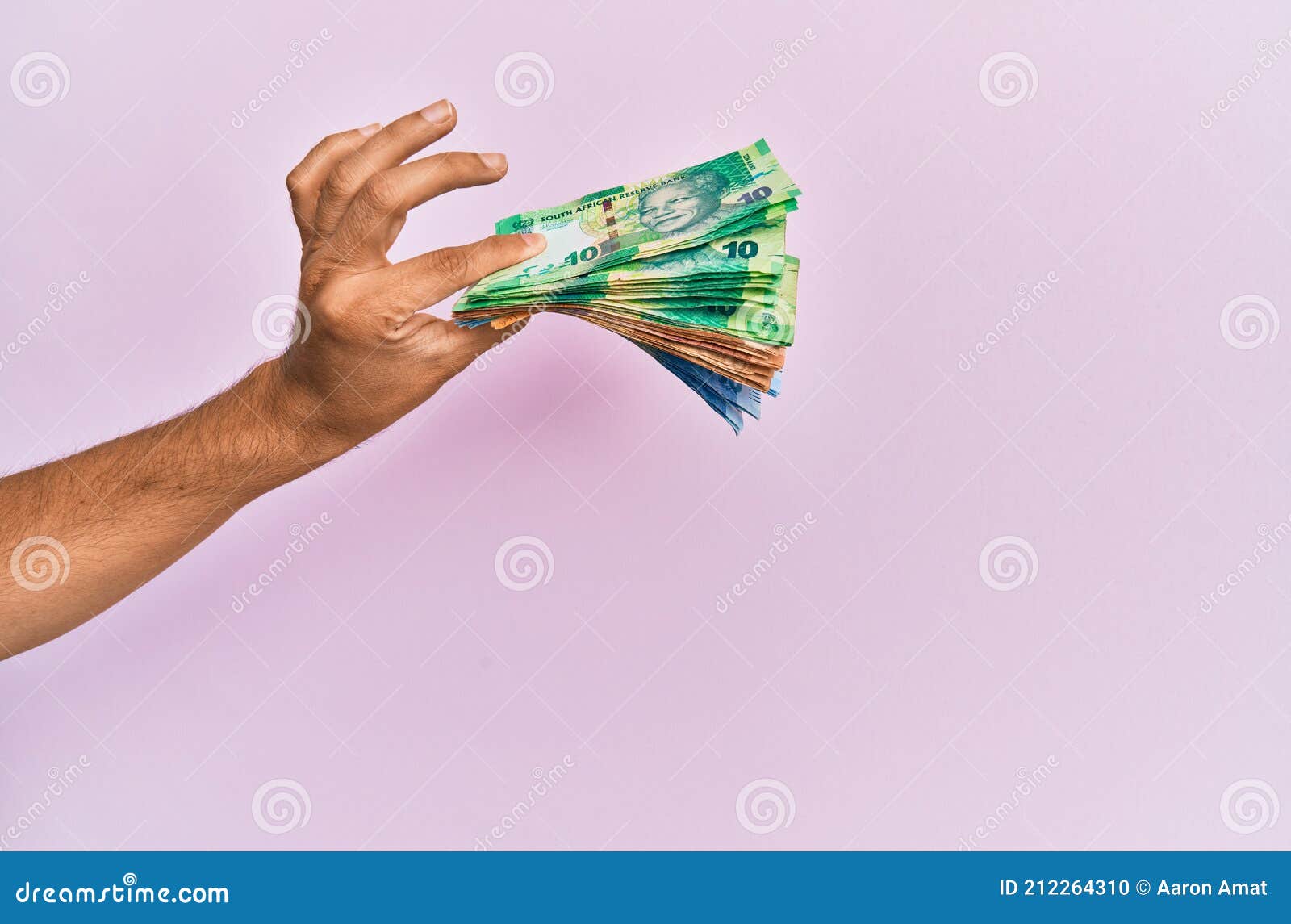 hispanic hand holding south africa rands banknotes over  pink background