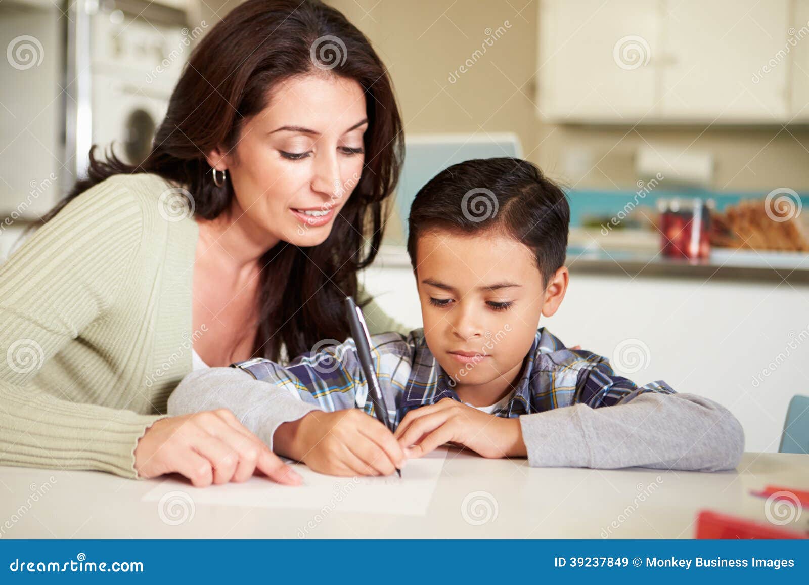 Hispanic Mother Helping Son With Homework At Table Stock Photo I
