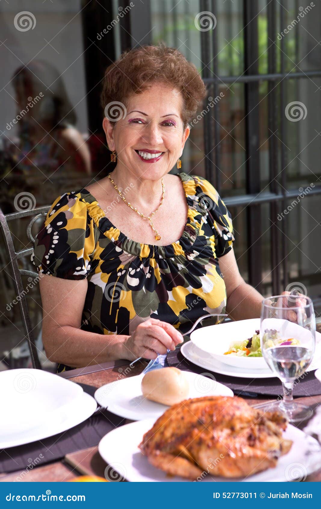 hispanic senior woman enjoying lunchtime outdoor in a home environment