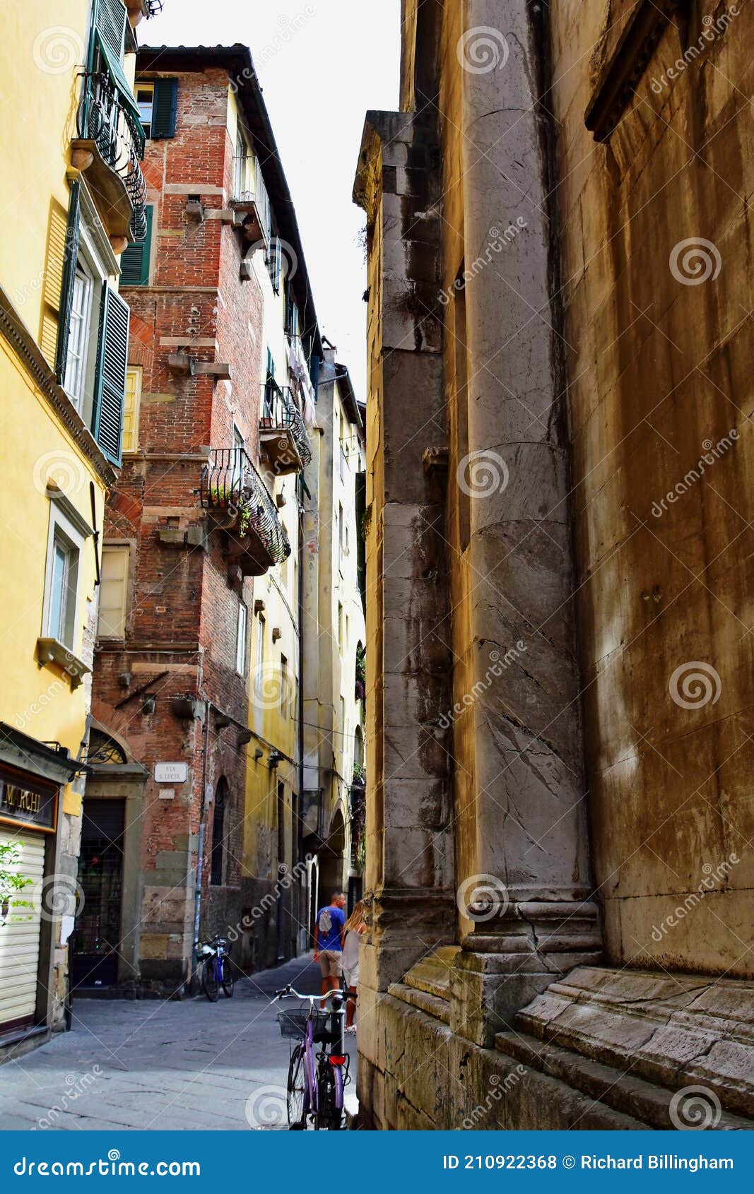 historic buildings on narrow strret, lucca, tuscany, italy