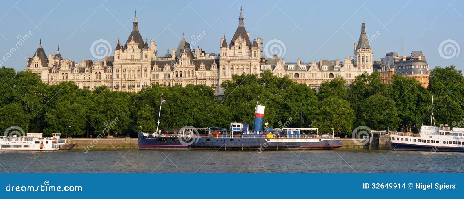 Historiska byggnader på Victoria Embankment, London. London Förenade kungariket - Juli 17, 2013: Historiska byggnader på Victoria Embankment. I förgrundsparti- & funktionsfartygen som förtöjas på Themsen, Rive.