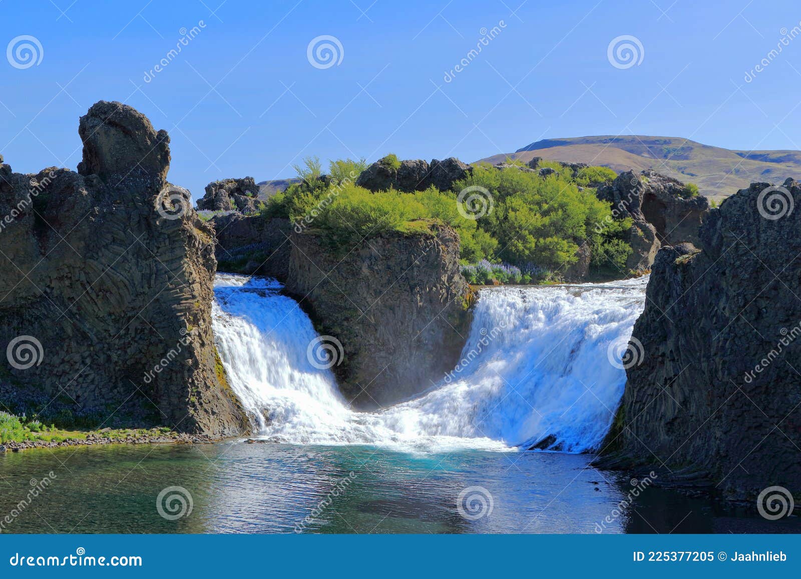 morning light on hjalparfoss waterfall in thjorsadalur framed with basalt columns, western iceland