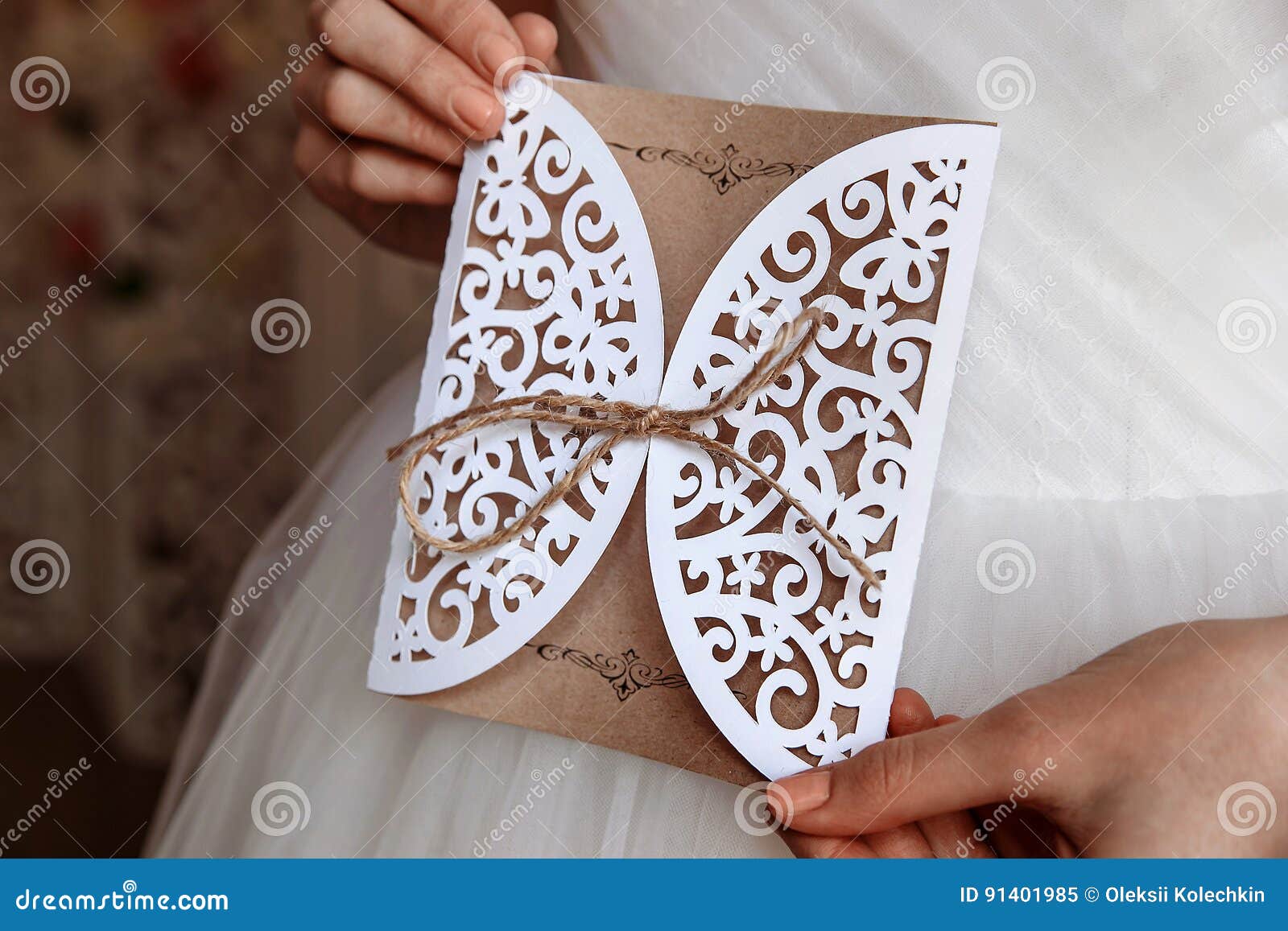 Hochzeitseinladungskarte in den Händen in der rustikalen Art