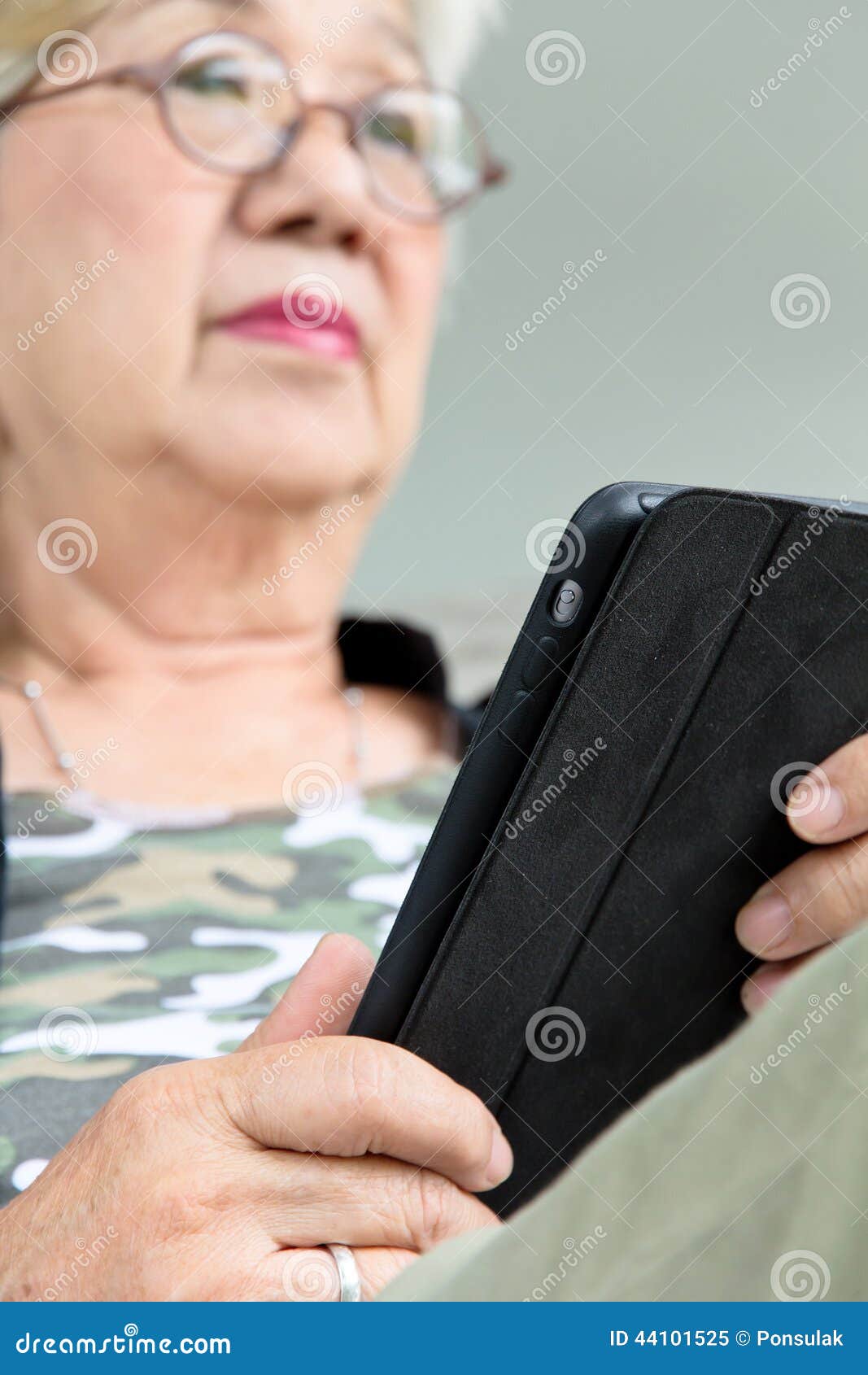 Hogere vrouw met tablet. Het hogere vrouw ontspannen thuis met tablet