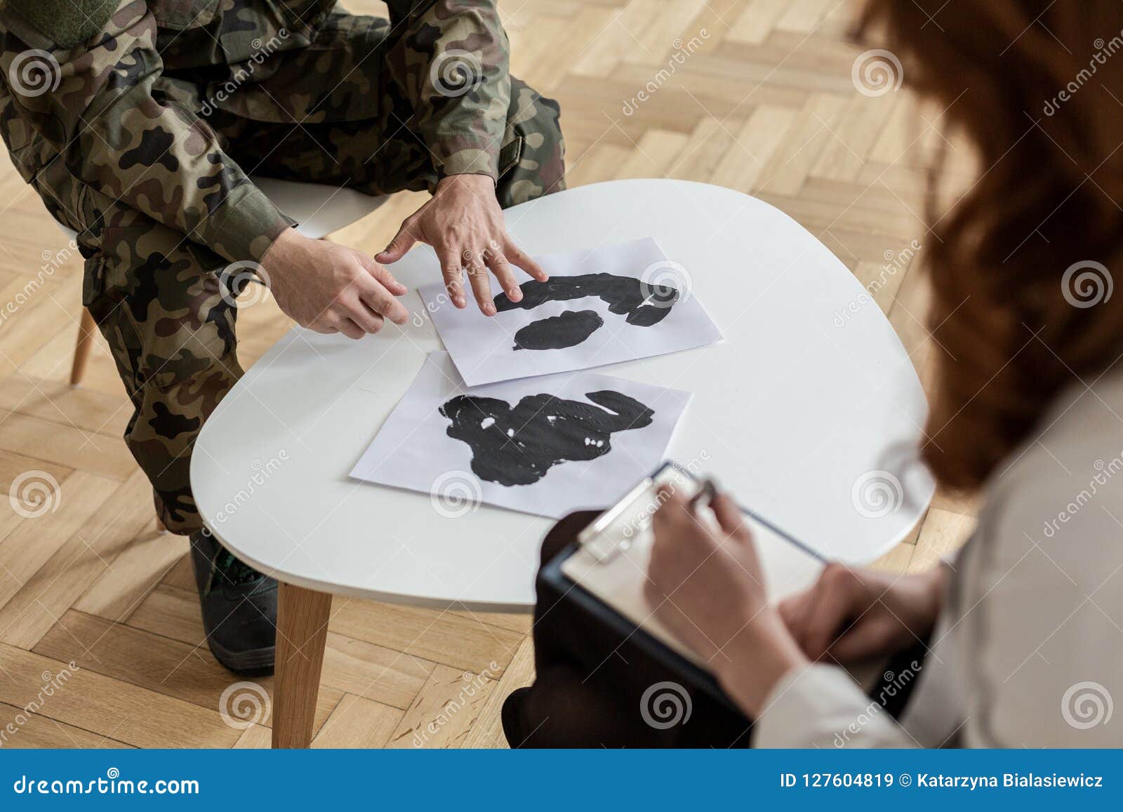 Hoher Winkel auf Soldaten in der grünen Uniform mit Poster während der Therapie mit Psychiaterskonzept