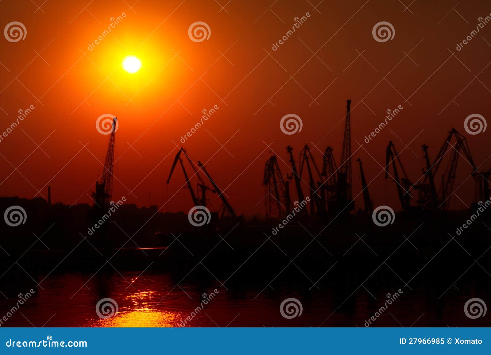 hoisting cranes on sunset