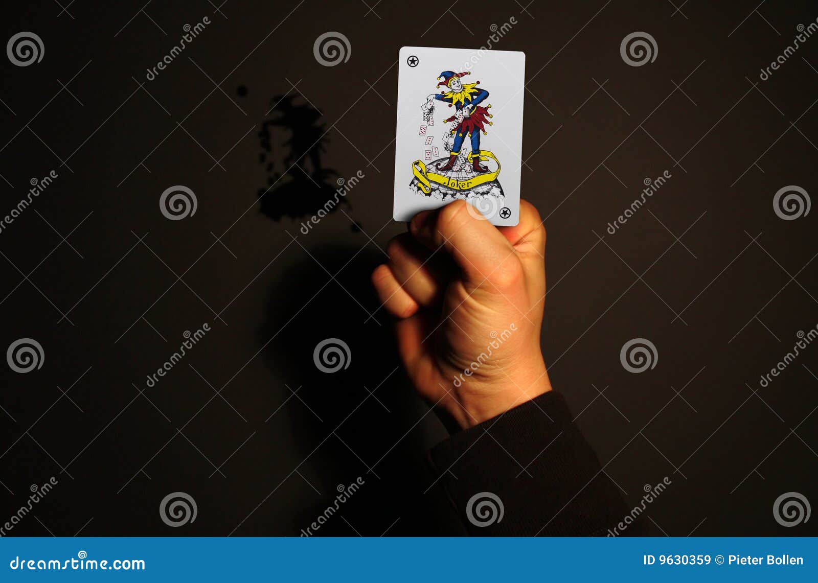 Holding joker card in hand stock image. Image of ideas 9630359