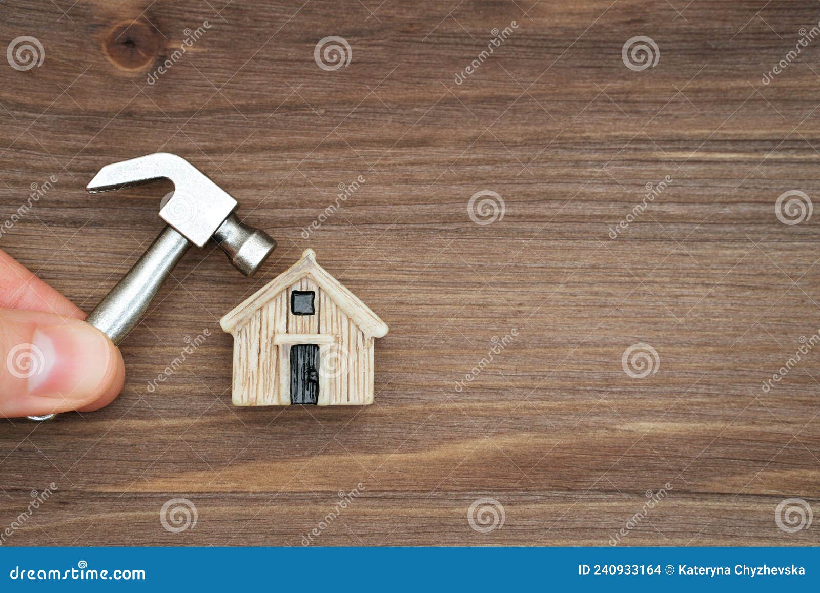 Holding a Miniature Hammer Close To a Tiny House Stock Photo
