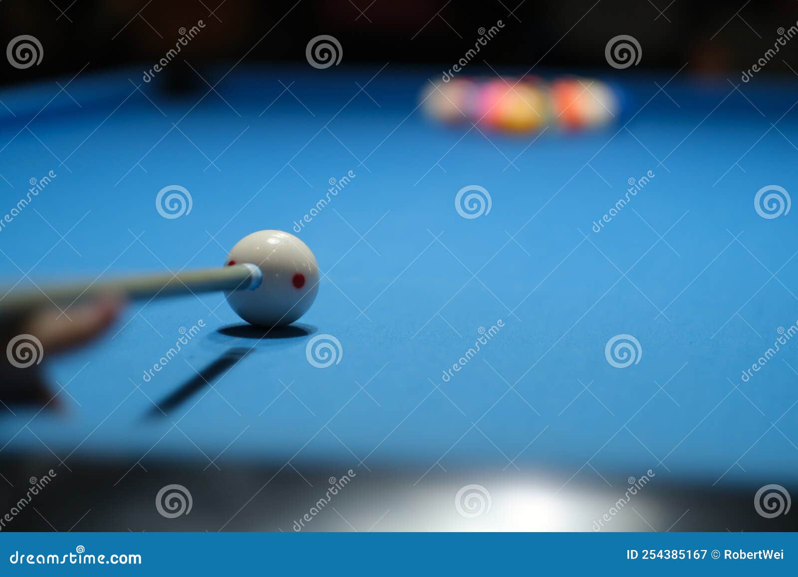 holding pool cue aiming at cue ball to break