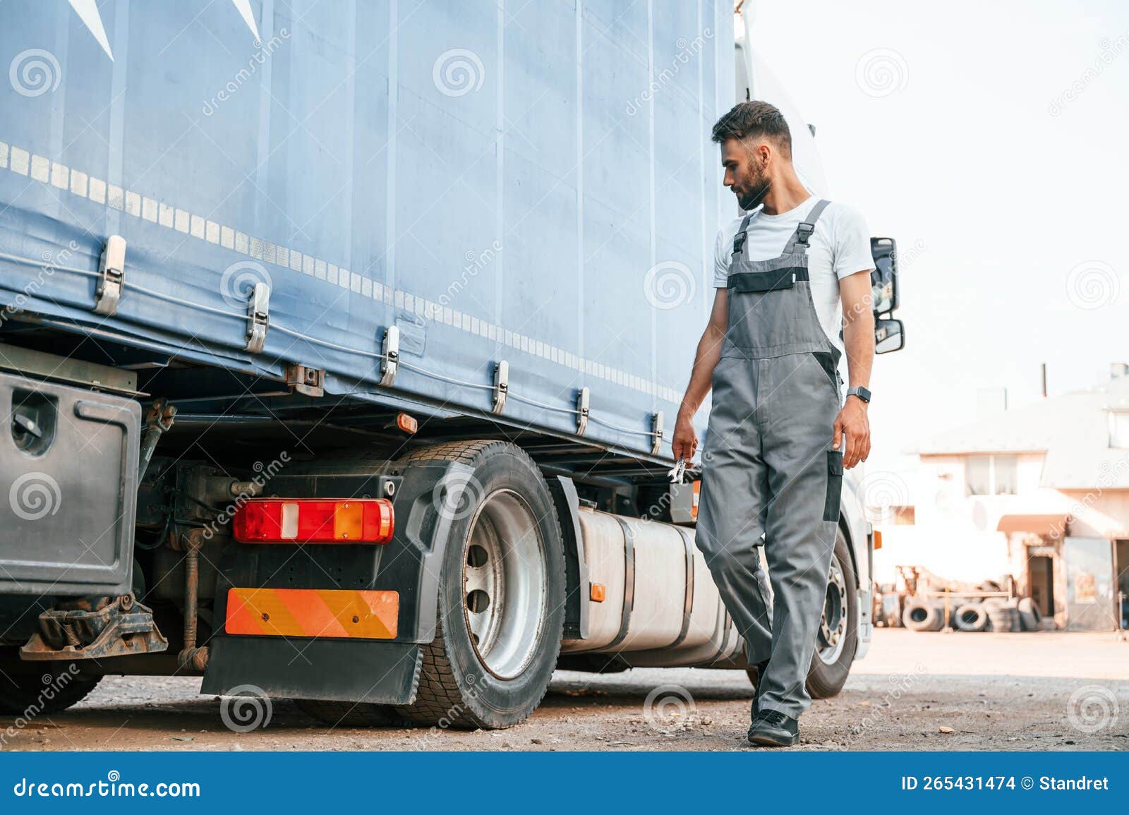 holding wrench. man in unifrom doing service for big truck vehicle