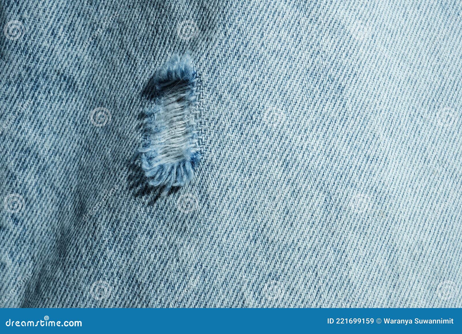 Hole and Threads on Denim Jeans. Ripped Destroyed Torn Blue Jeans
