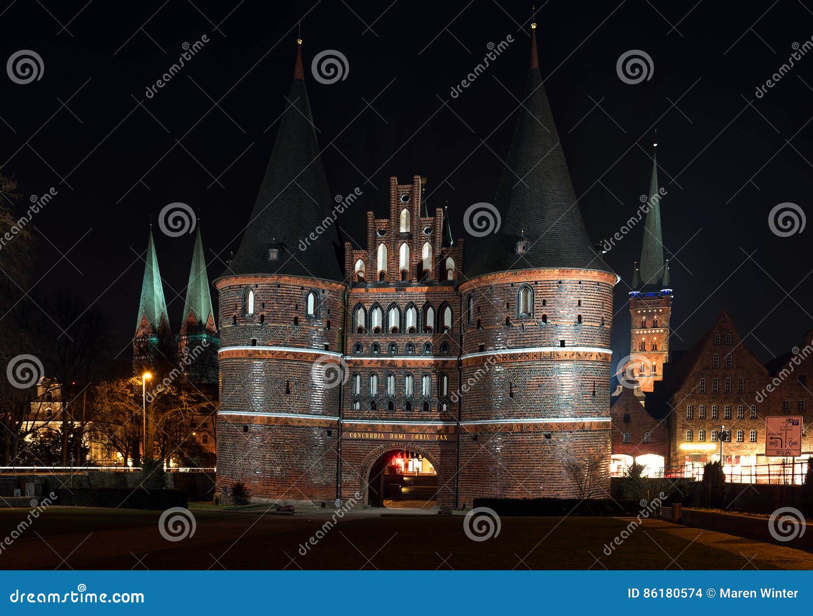 holstentor and church towers in luebeck iluminated at night, med