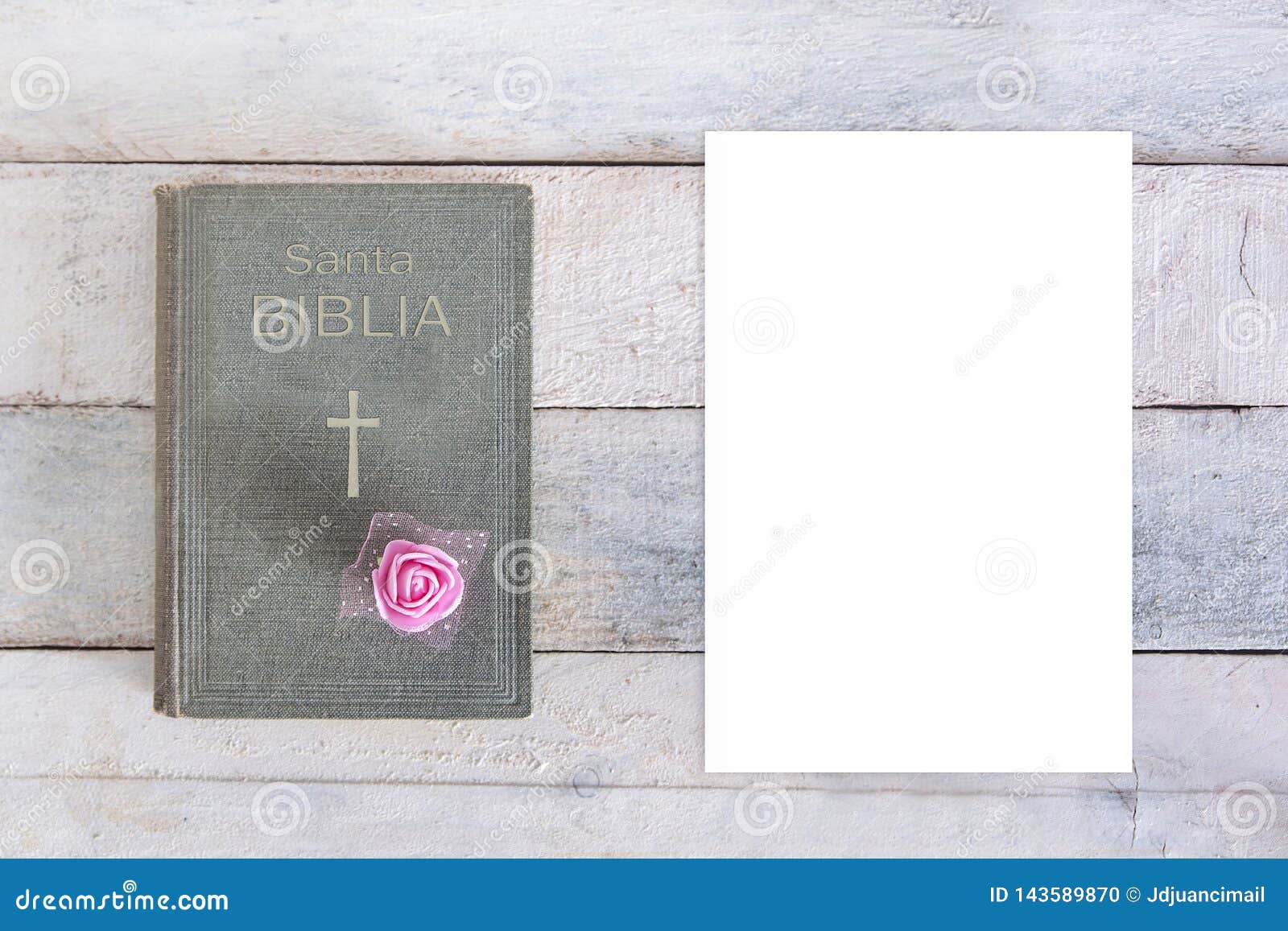 holy bible with the word biblia in spanish and a cross sign and a rose flower decoration next a blank white paper