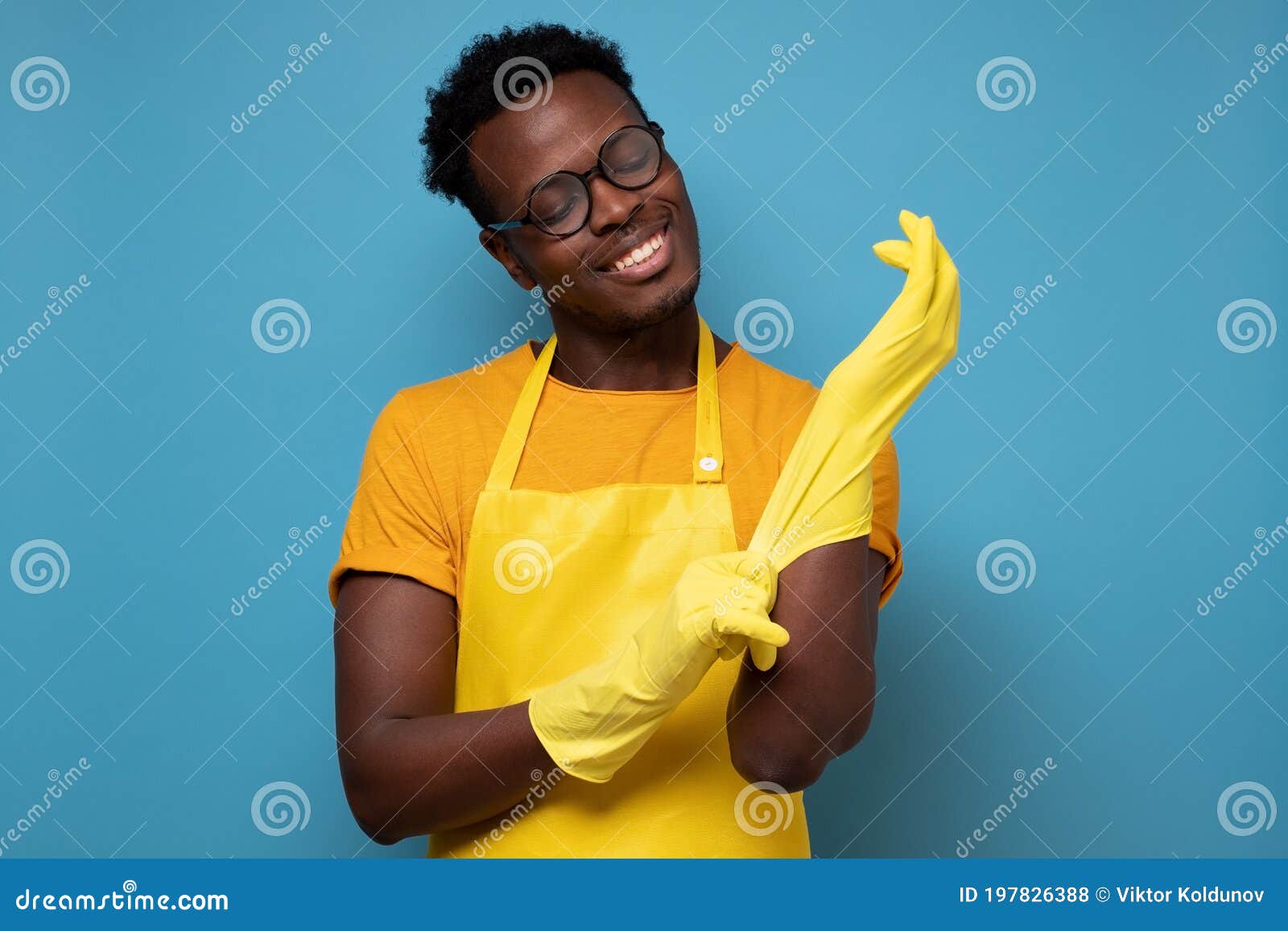Joven con guantes de goma amarillos listo para limpiar