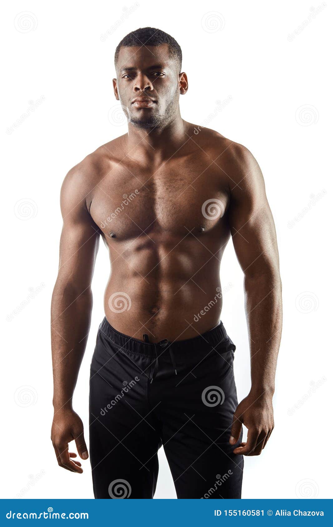 Modelo de fitness hombre atlético fuerte con cuerpo perfecto vistiendo  camiseta negra posando aislada sobre fondo oscuro. concepto de culturismo