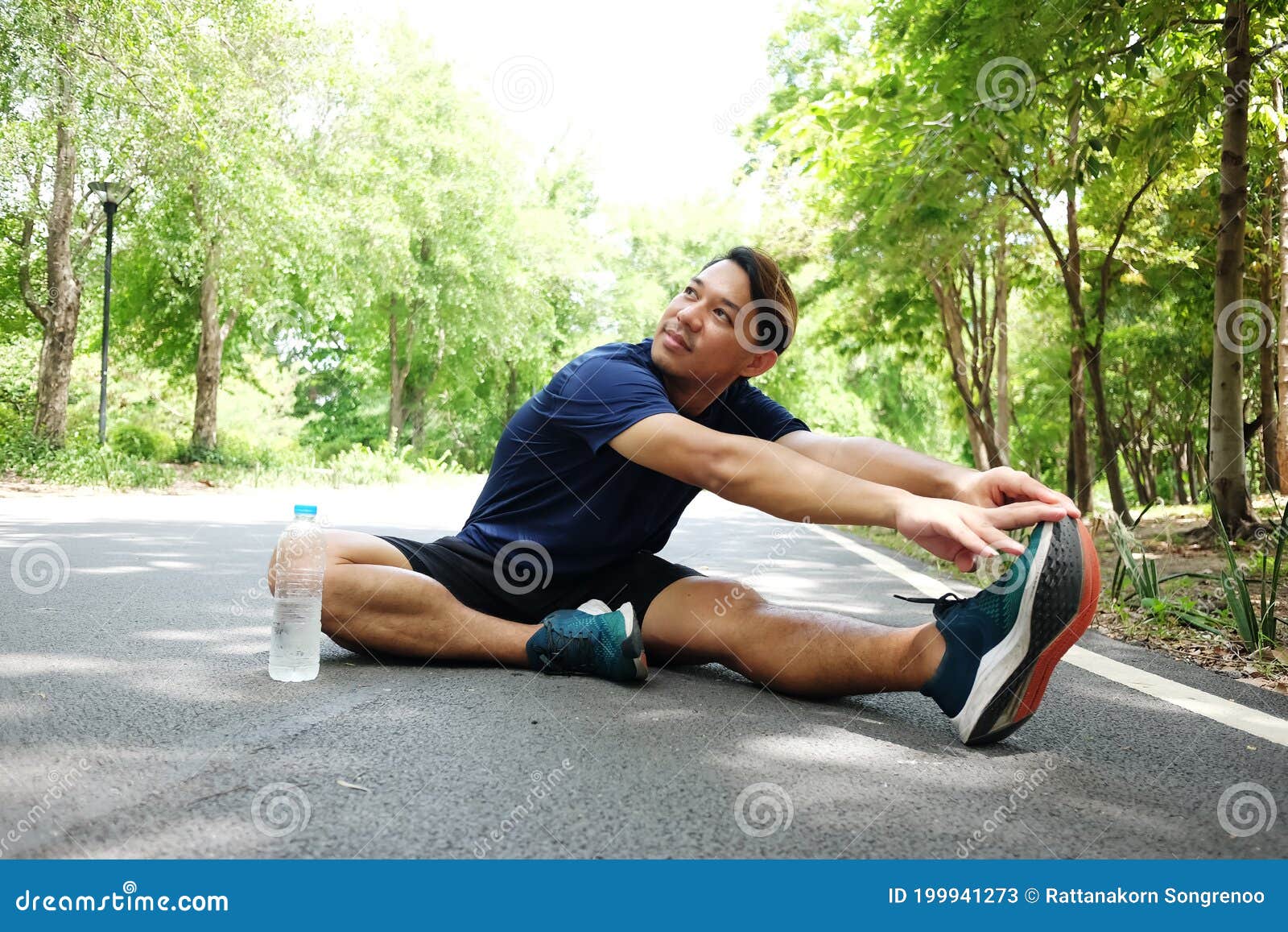 Hombre Asiático Sonriente Sentado En El Suelo De Hormigón Hacer Ejercicio Y Estirar Las Piernas Para Relajar Los Músculos De Imagen de archivo - Imagen de actividad, piernas: 199941273