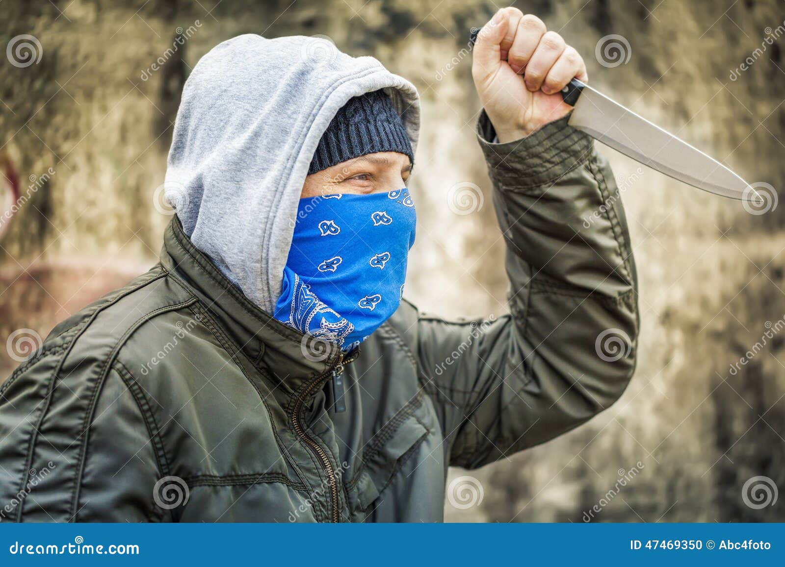 Hombre con el cuchillo cerca de la pared vieja. Hombre con el cuchillo cerca del viejo día del otoño de la pared