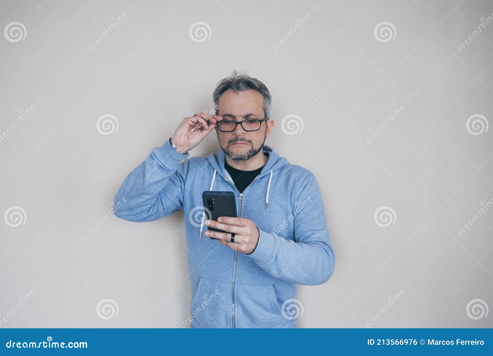 Hombre Con Gafas Con Presbicia Mirando El Teléfono Foto de archivo - Imagen  de edad, texto: 213566976