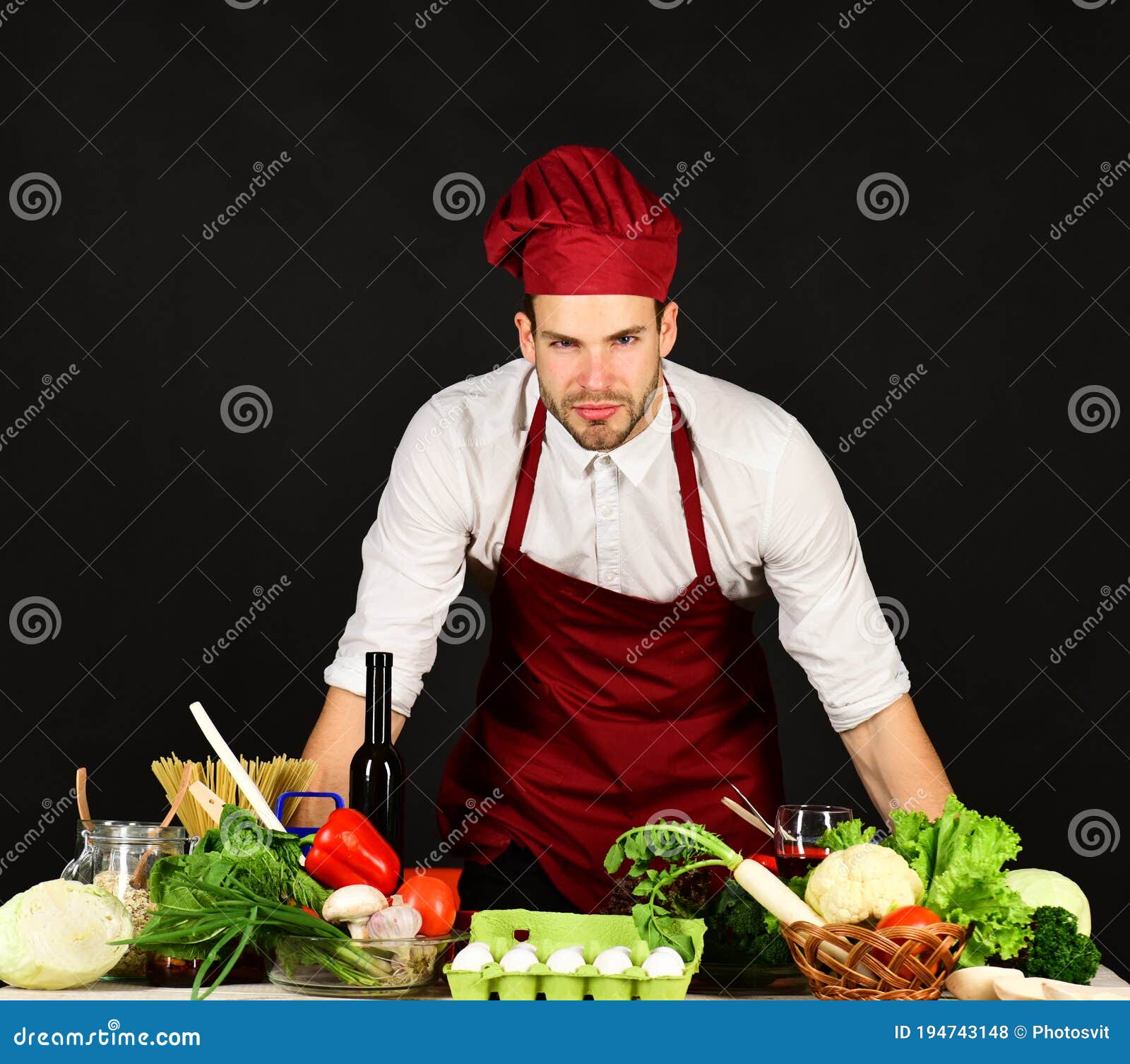 Hombre con delantal y sombrero de chef cocinando comida en la