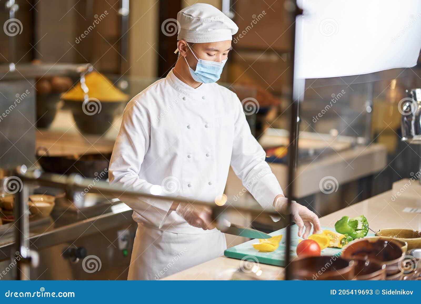 Hombre En Los Pimientos De Corte Con Uniforme De En La Cocina Imagen de archivo Imagen de carrera: 205419693