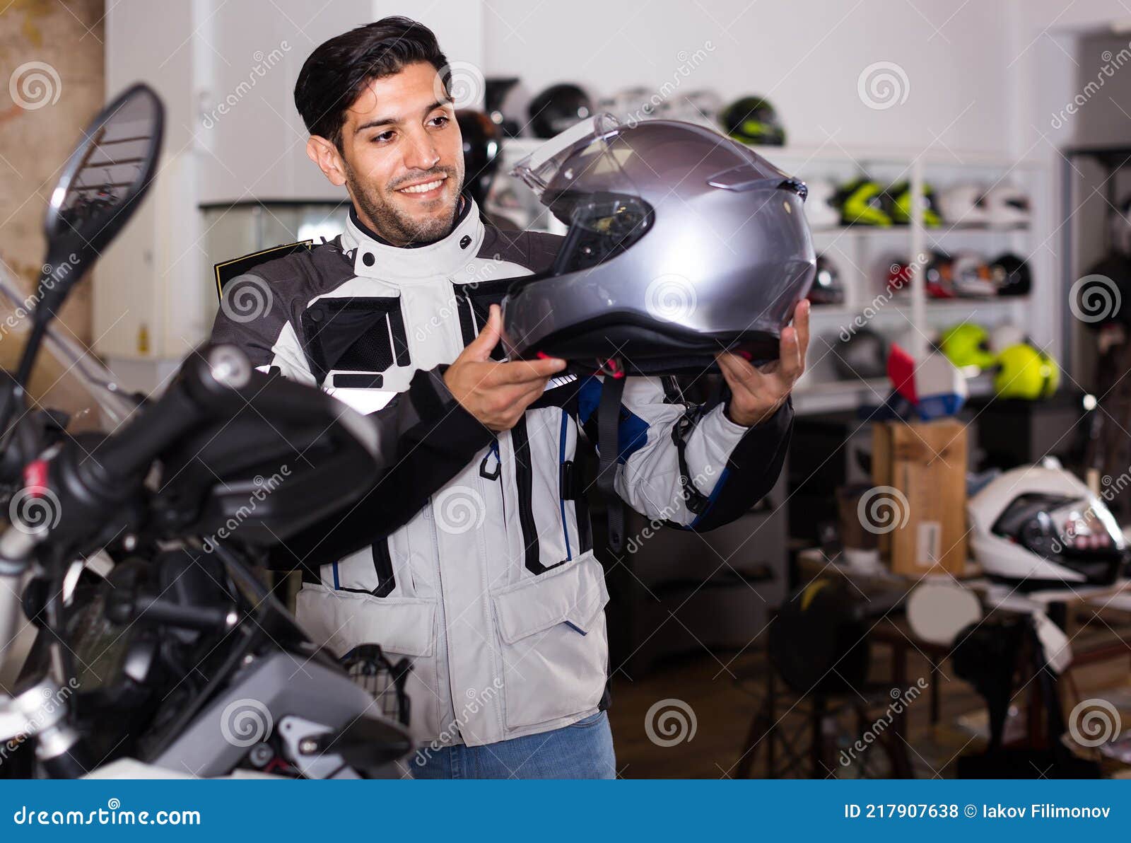 Hombre En Moto Chaqueta Está Eligiendo Nuevo Casco Para Moto En La Tienda.  Foto de archivo - Imagen de moderno, motocicleta: 217907638