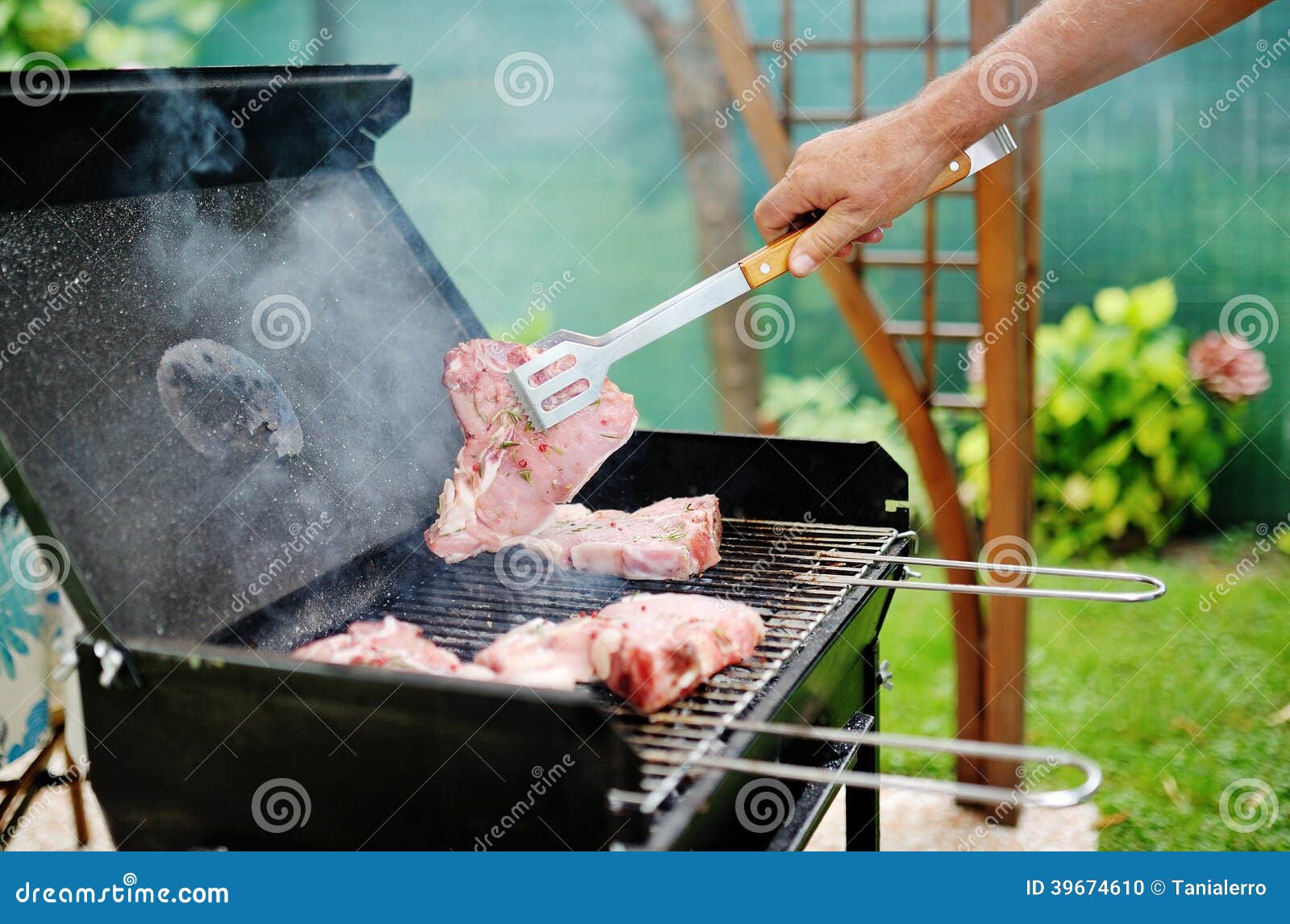 Hombre En Una Parrilla De La Barbacoa Que Prepara La Carne Para