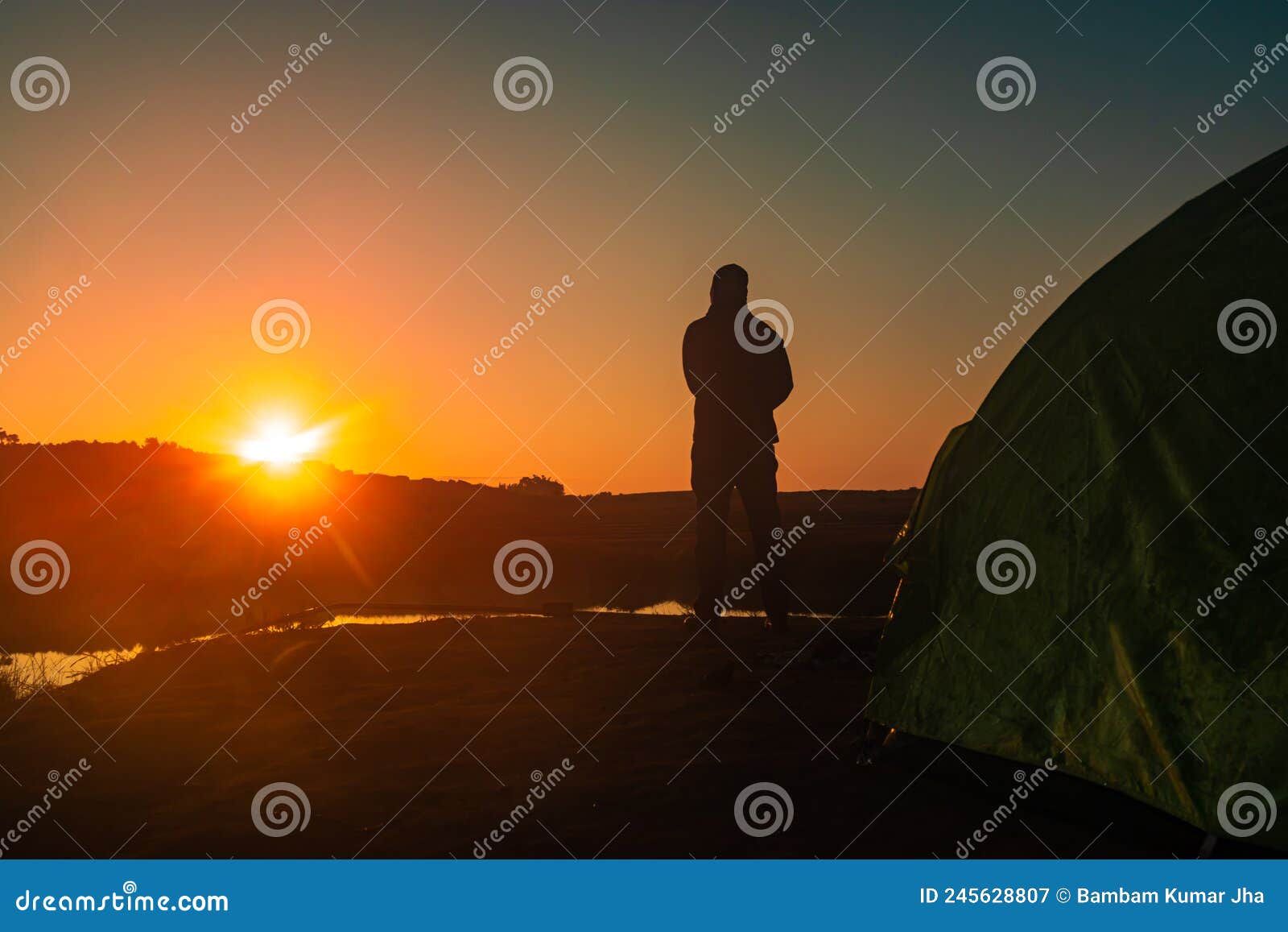 Hombre Iluminado De Espaldas Con Amanecer Sobre La Sombra De La Montaña Y  Lago Tranquilo Con Reflexión En La Mañana Imagen de archivo - Imagen de  brazos, asimiento: 245628807