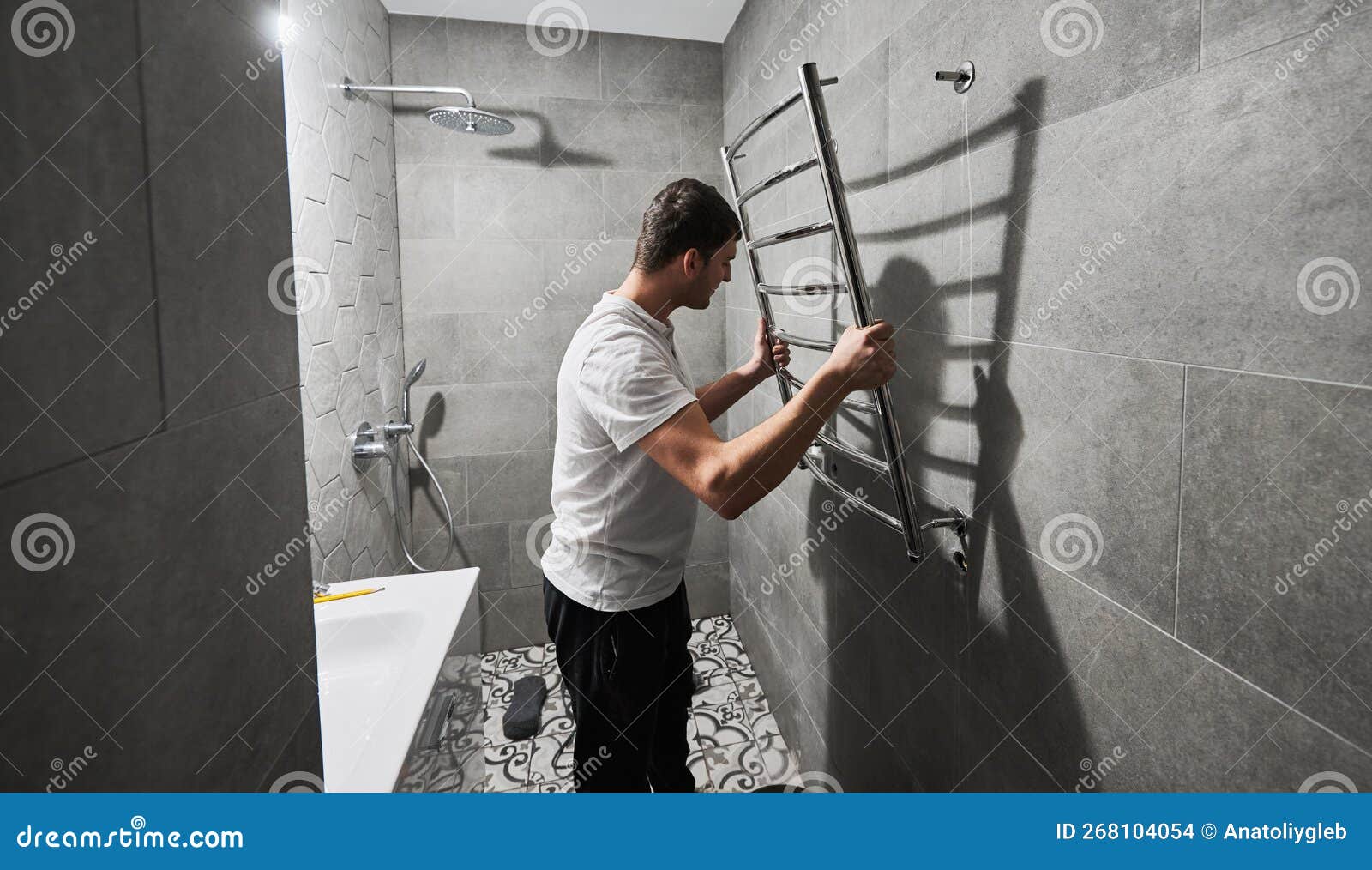 Hombre Instalando Un Toallero Eléctrico Calentado En El Baño. Foto de  archivo - Imagen de fontanero, capataz: 268104054