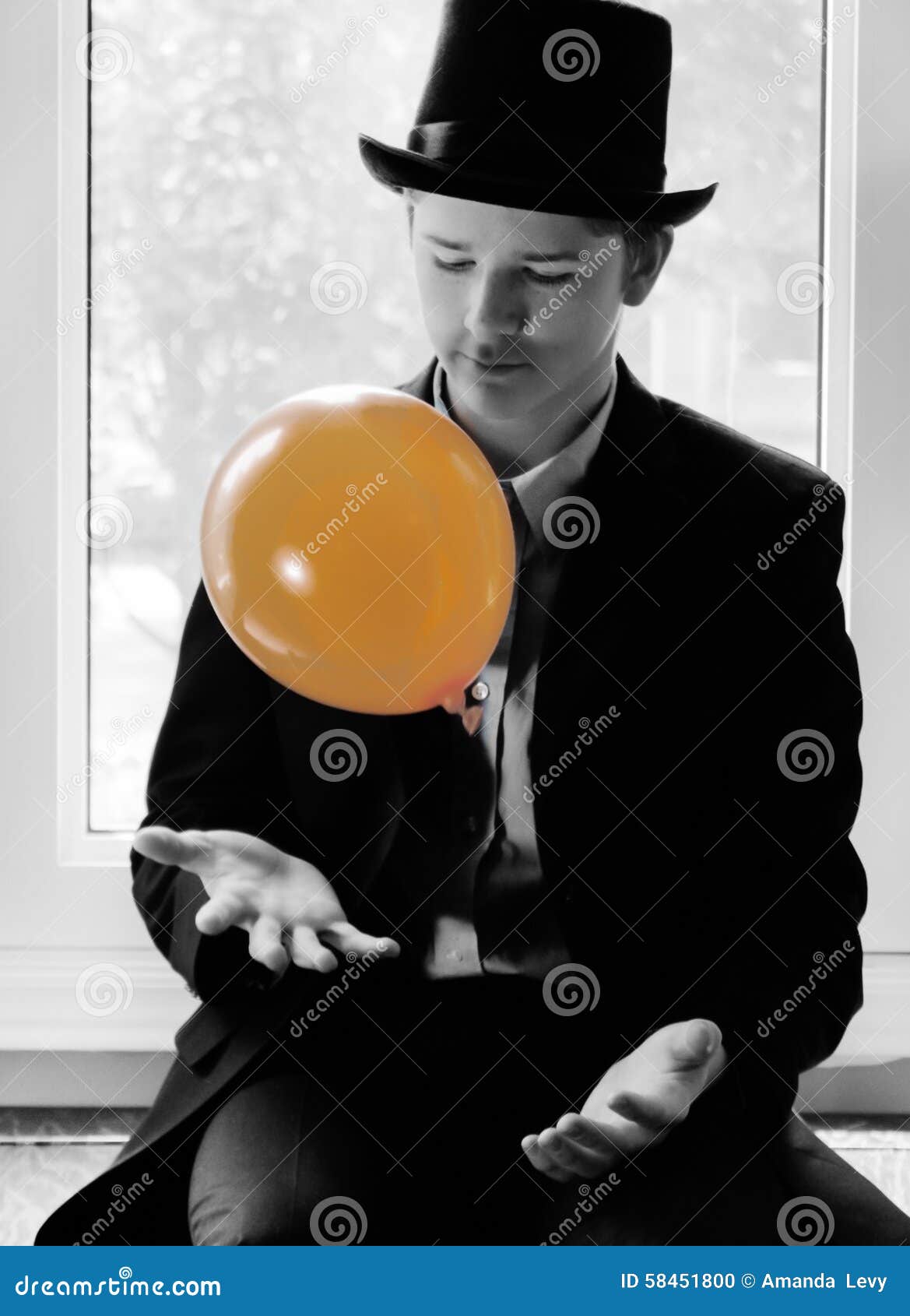 Hombre joven con el globo anaranjado. Retrato blanco y negro de un hombre joven de lujo con el globo anaranjado