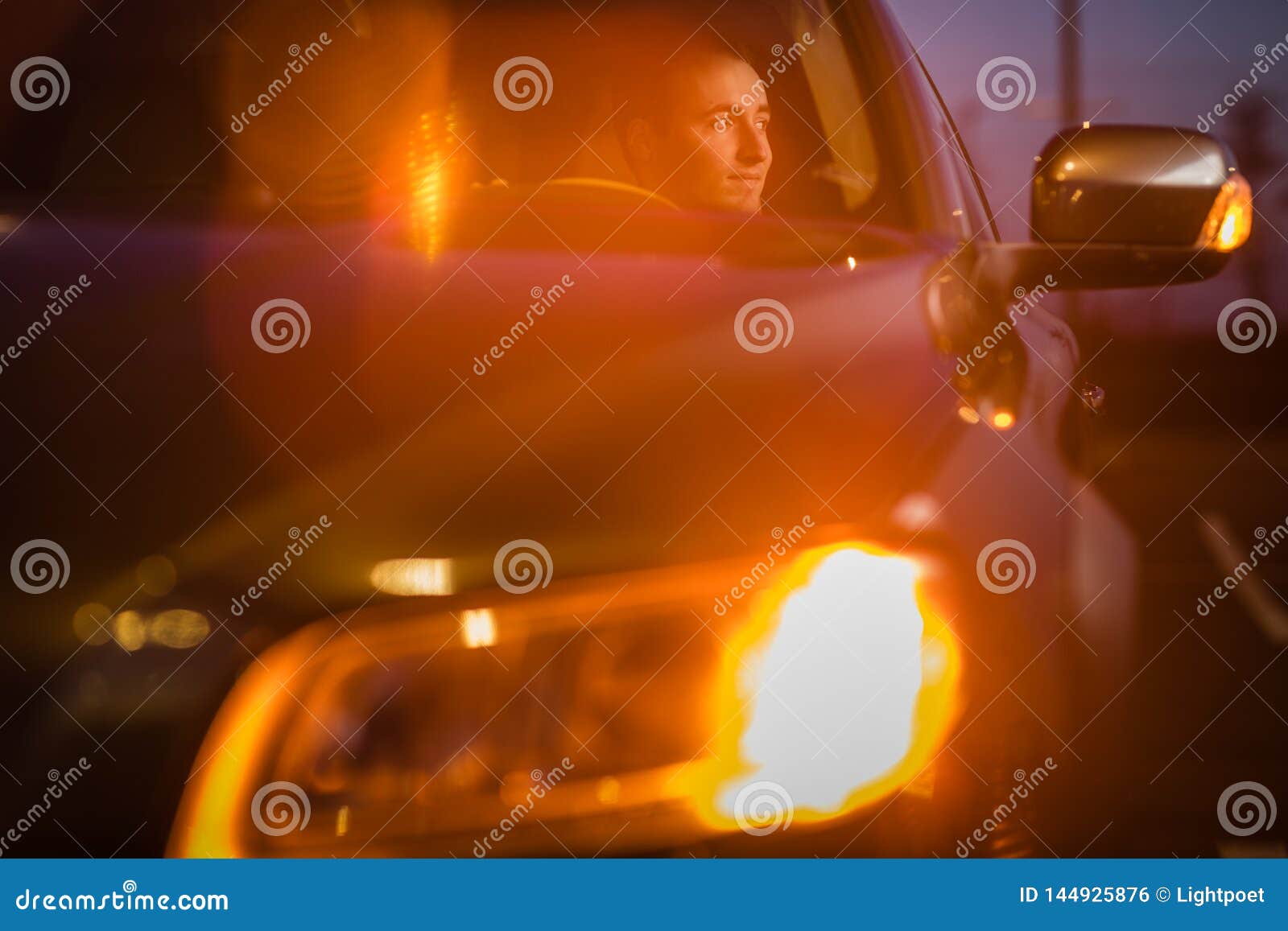 Hombre joven hermoso que conduce su coche en la noche. Hombre joven hermoso que conduce su coche en la imagen entonada color de la noche