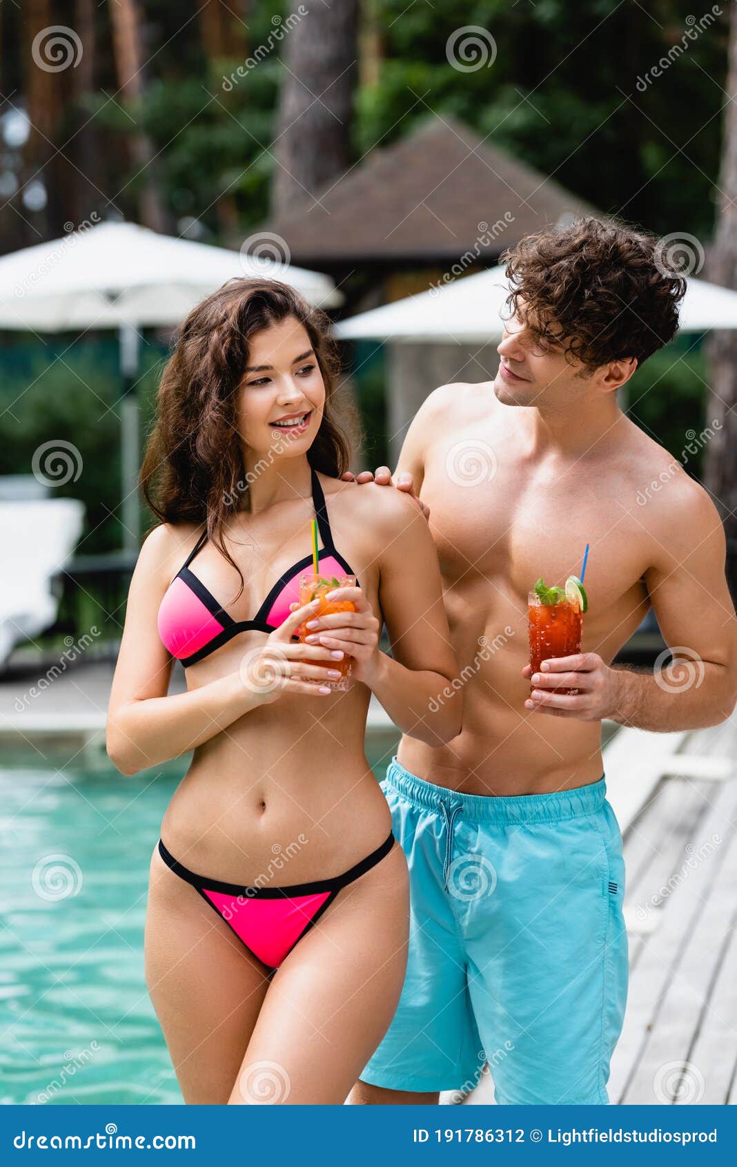 Hombre Mirando a Una Chica En Ropa De Baño Sosteniendo Un Cóctel Foto de  archivo - Imagen de afuera, verano: 191786312