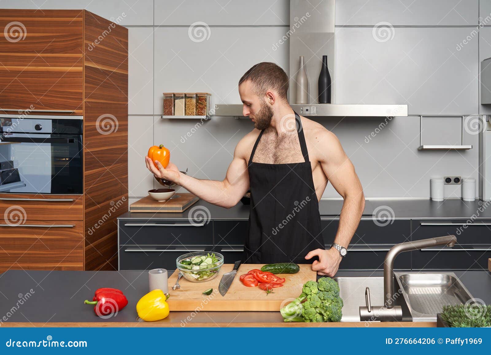 Hombre Muscular Hermoso En Un Delantal De Cocina En La Cocina De