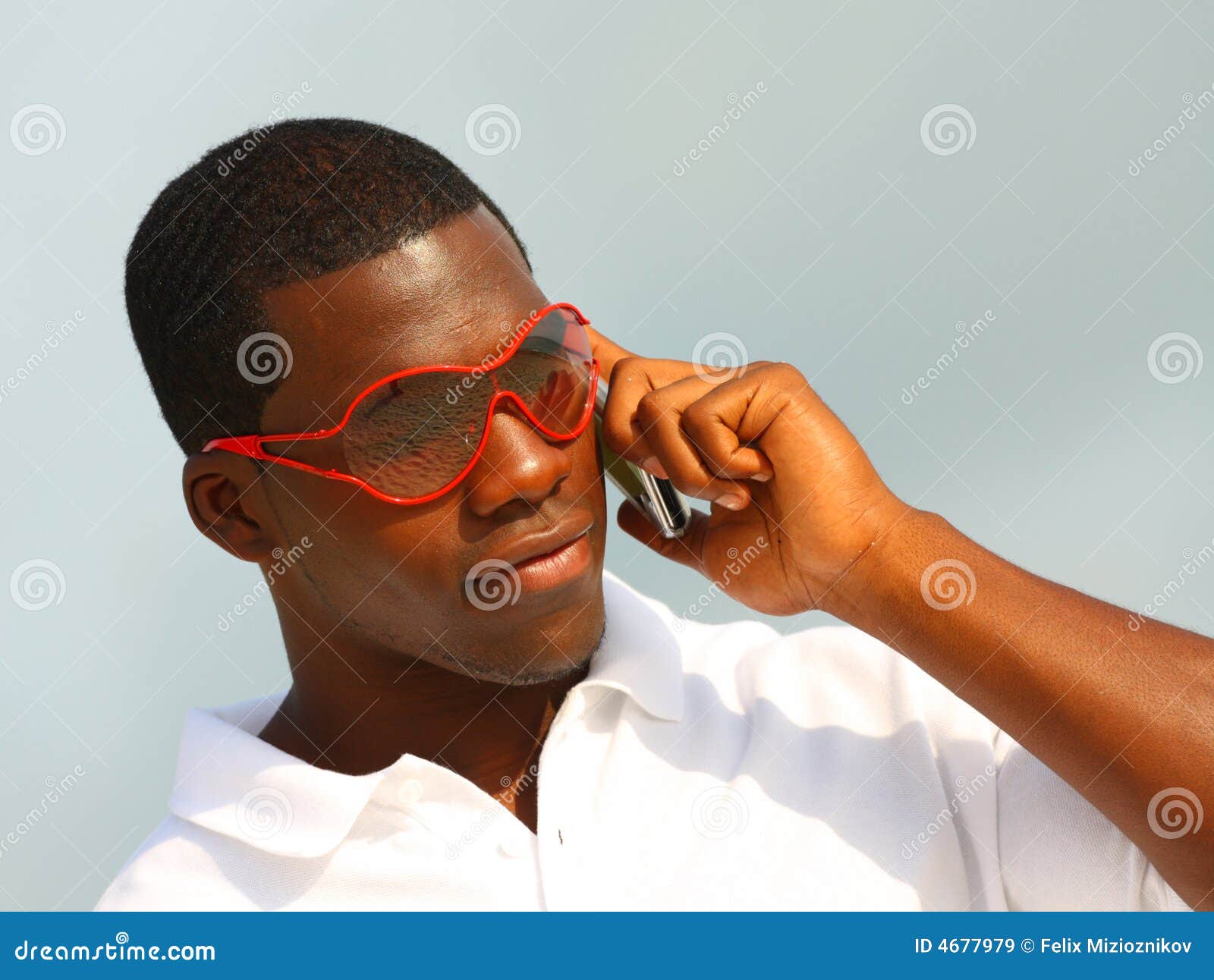 Hombre que habla en el teléfono. Sirva sostener un teléfono celular con las gafas de sol rojas.