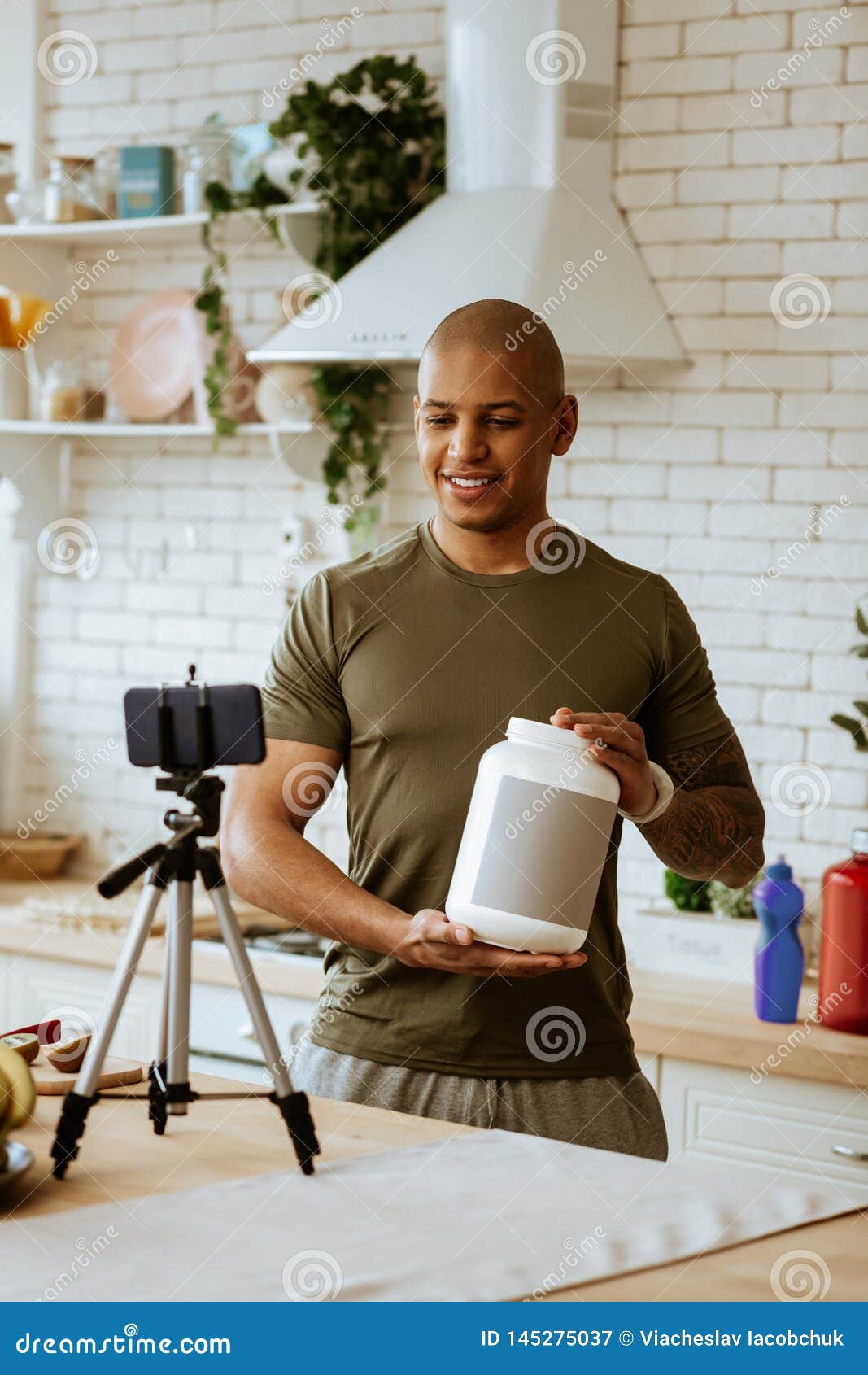 Hombre Que Lleva La Proteína De Recomendación De La Camisa De Color Caqui  Para Los Seguidores Imagen de archivo - Imagen de poderoso, atleta:  145275037