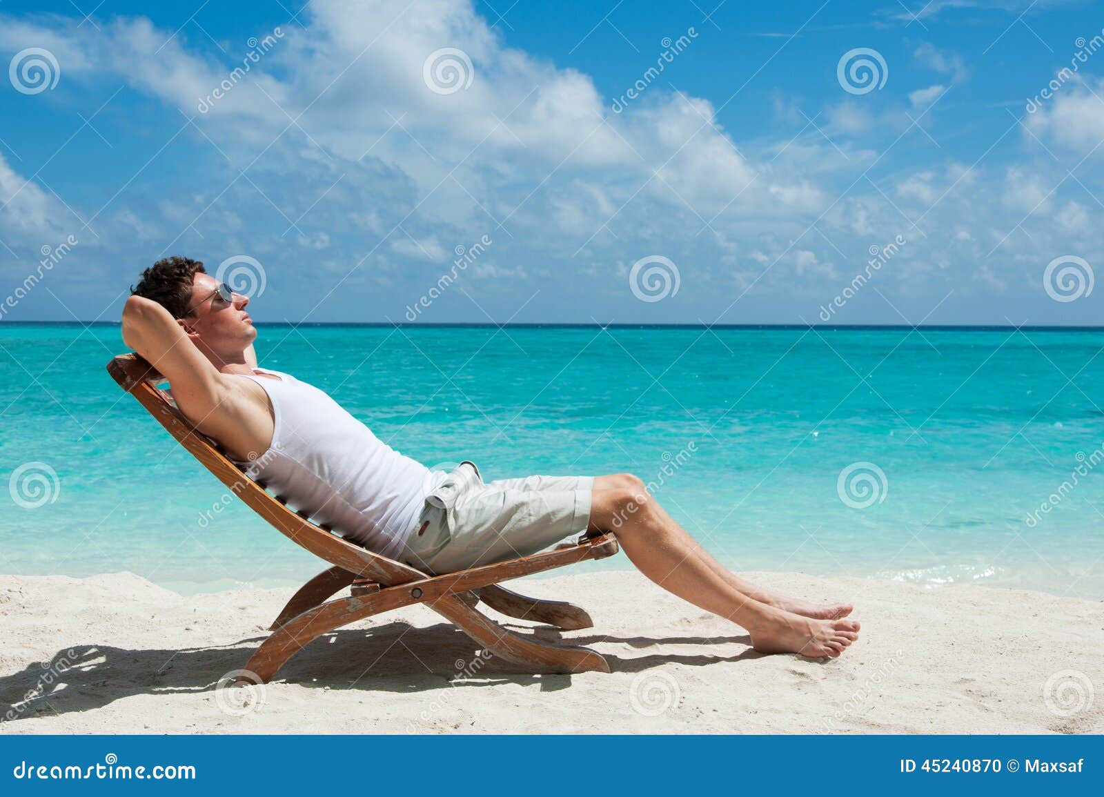 Hombre Que Toma El Sol En La Playa Foto de archivo - Imagen de silla