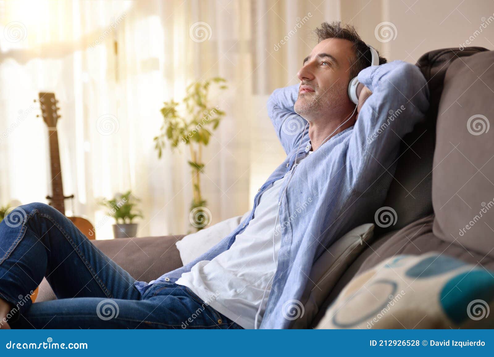 Hombre Relajado Escuchando Música En Casa Sentado En El Sofá Foto de  archivo - Imagen de placer, perdido: 212926528