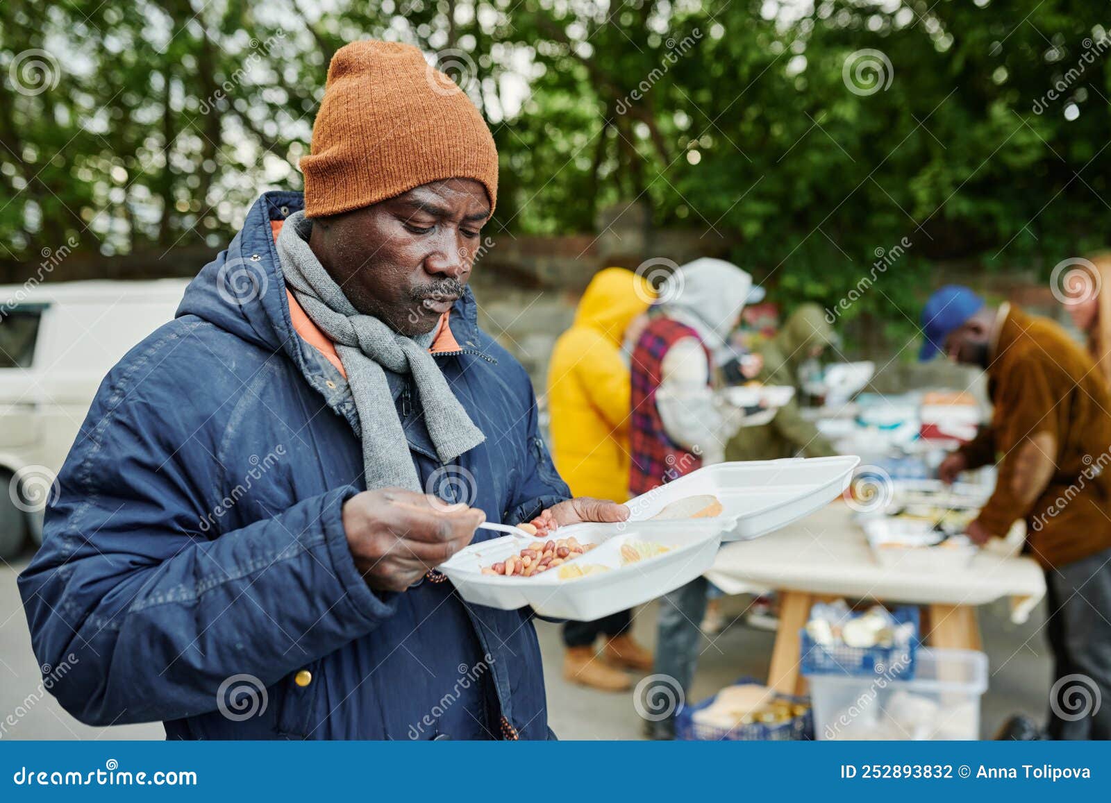 Hombre Sin Hogar Africano Comiendo Comida De Caridad Foto de