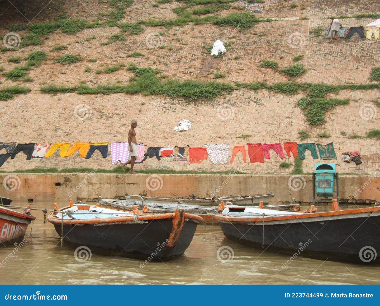 hombre tendiendo la ropa delante del rio ganges en varanasi india